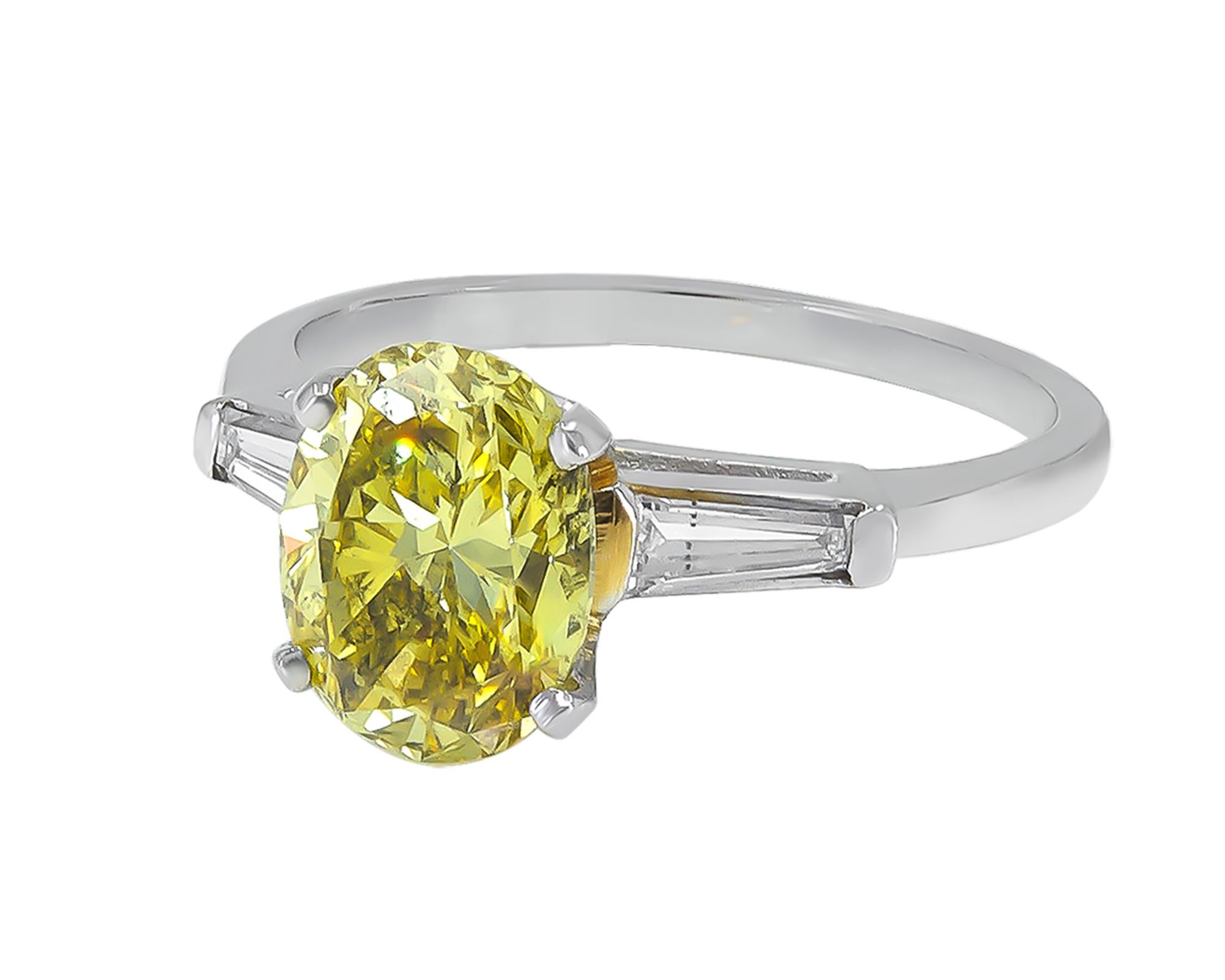 A classic engagement ring featuring a 2.14 carat oval fancy vivid yellow diamond with SI2 clarity.
The yellow diamond is accompanied by a GIA report.
There are 2 baguette diamonds on the sides weighing 0.65 carats.
The metal is platinum weighing