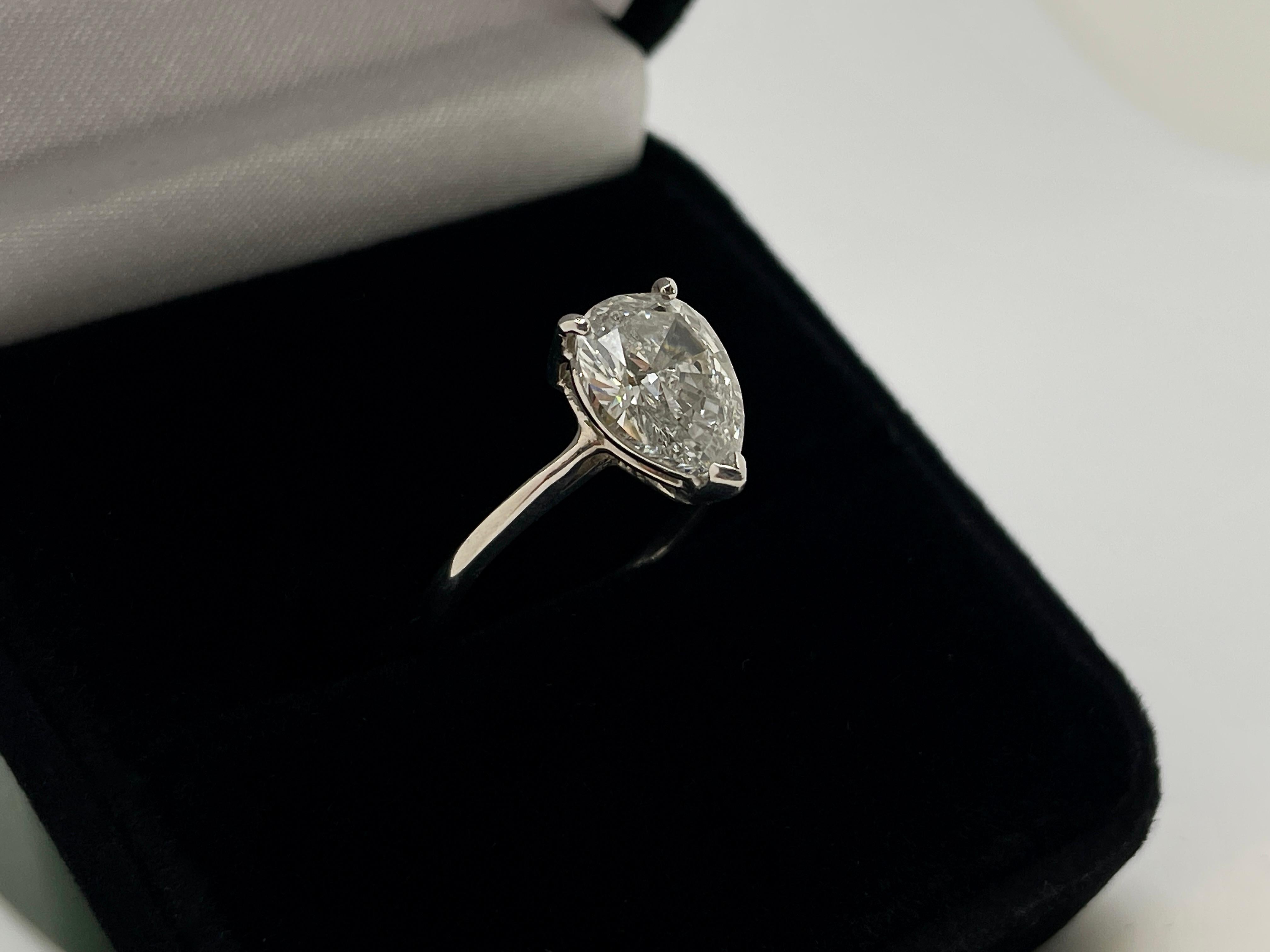 Un original anillo de compromiso de diamantes de oro blanco de 14 quilates certificado por el GIA. Montado con un impresionante diamante en forma de pera natural de 2,16 TC, color E y claridad SI2, que mide 10,52 x 7,73 x 4,22 mm. Engarzada en oro