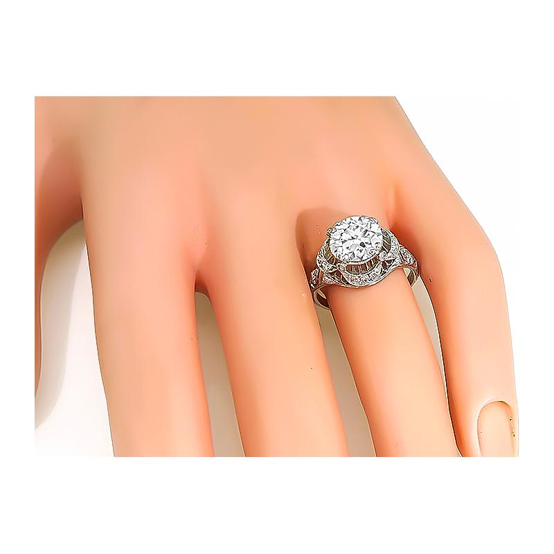 This is a stunning platinum engagement ring from the Art Deco era. The ring is centered with a sparkling GIA certified round cut diamond that weighs 2.16ct. The color of the diamond is F with SI1 clarity. The center diamond is accentuated by small