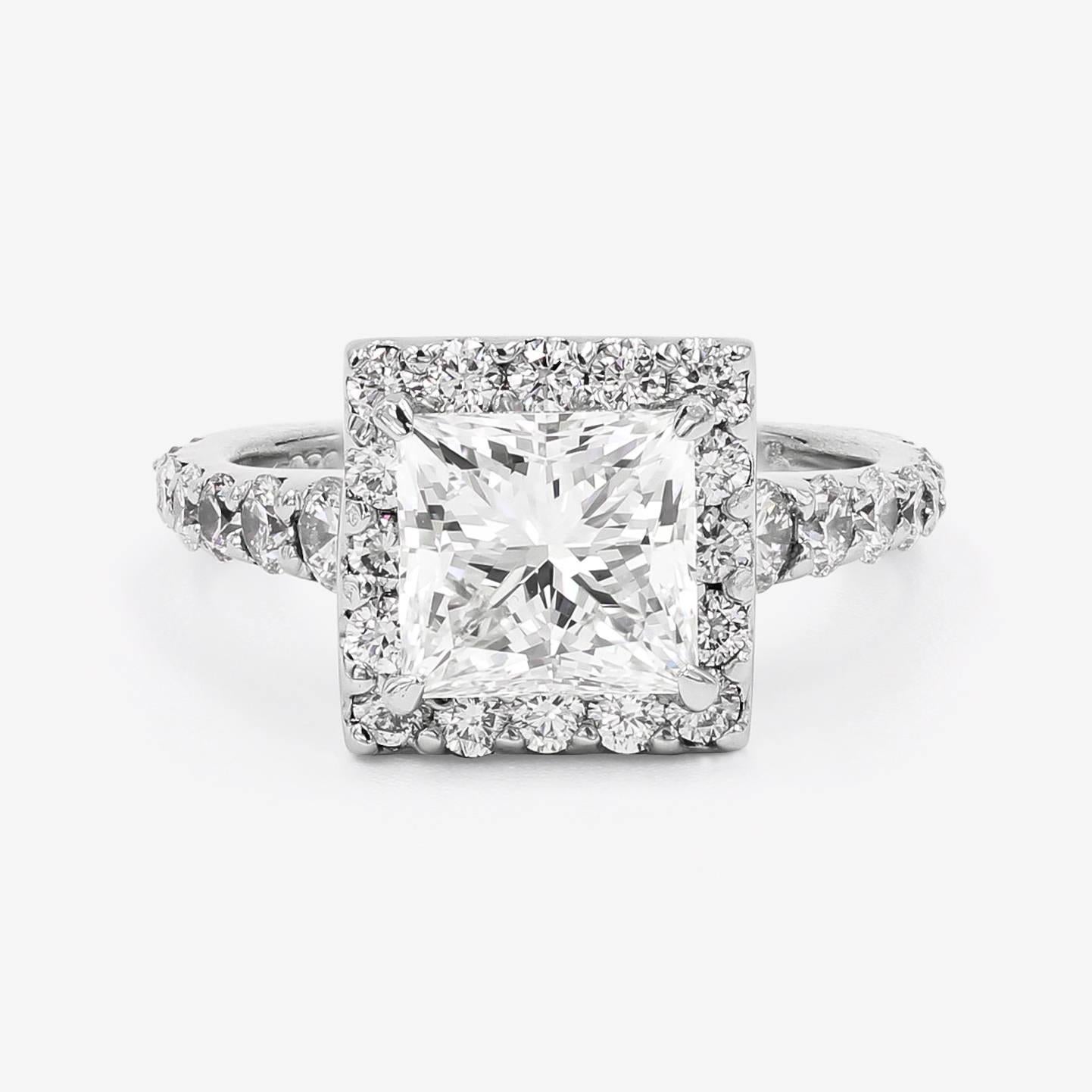 This classic platinum ring contains a center 2.19cts. princess cut center H color and VVS2 clarity, and 32 ideal cut round diamonds= 1.14cts. t.w. set in a halo style around the center and down the sides of the shank. (accent diamonds are