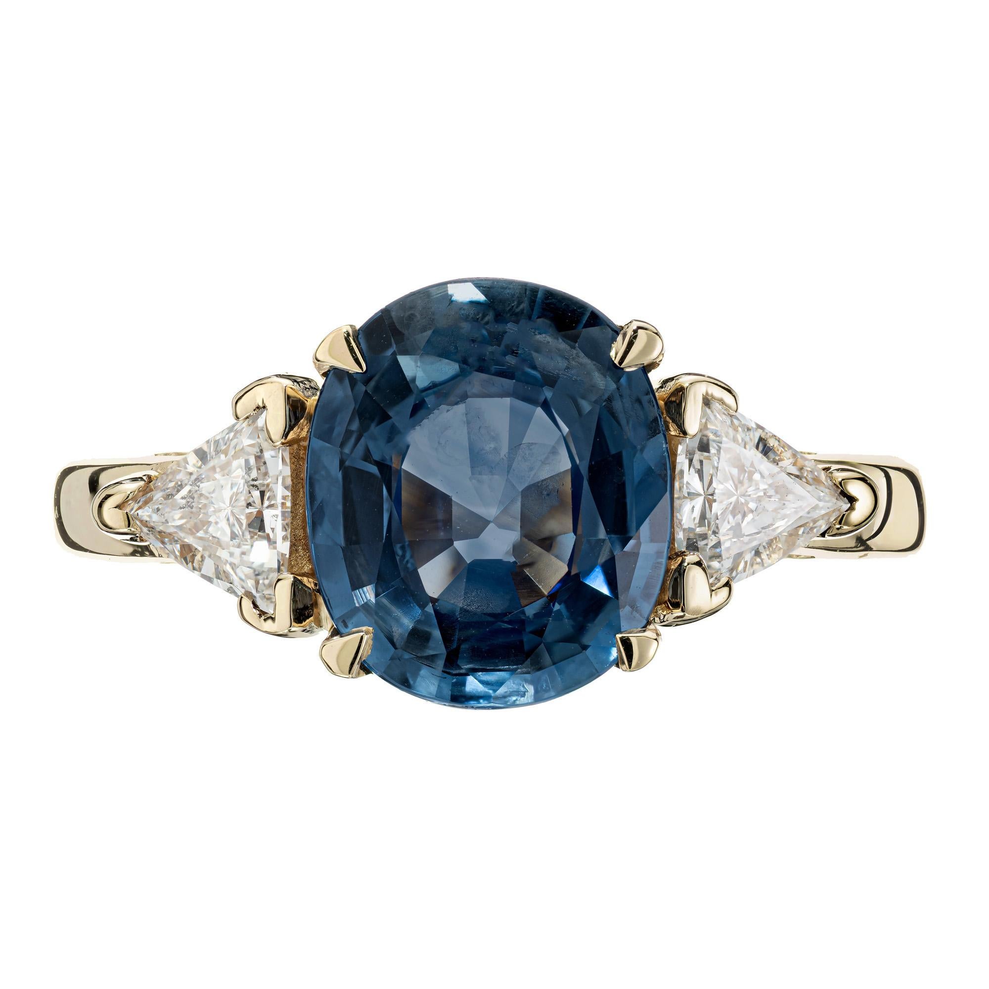 Natural Blue Oval Sapphire Diamond Three-Stone Gold engagement ring. GIA certified oval natural no heat sapphire center stone with 2 trilliant cut side diamonds in a 14k yellow setting. 

1 oval soft medium blue Sapphire, approx. total weight