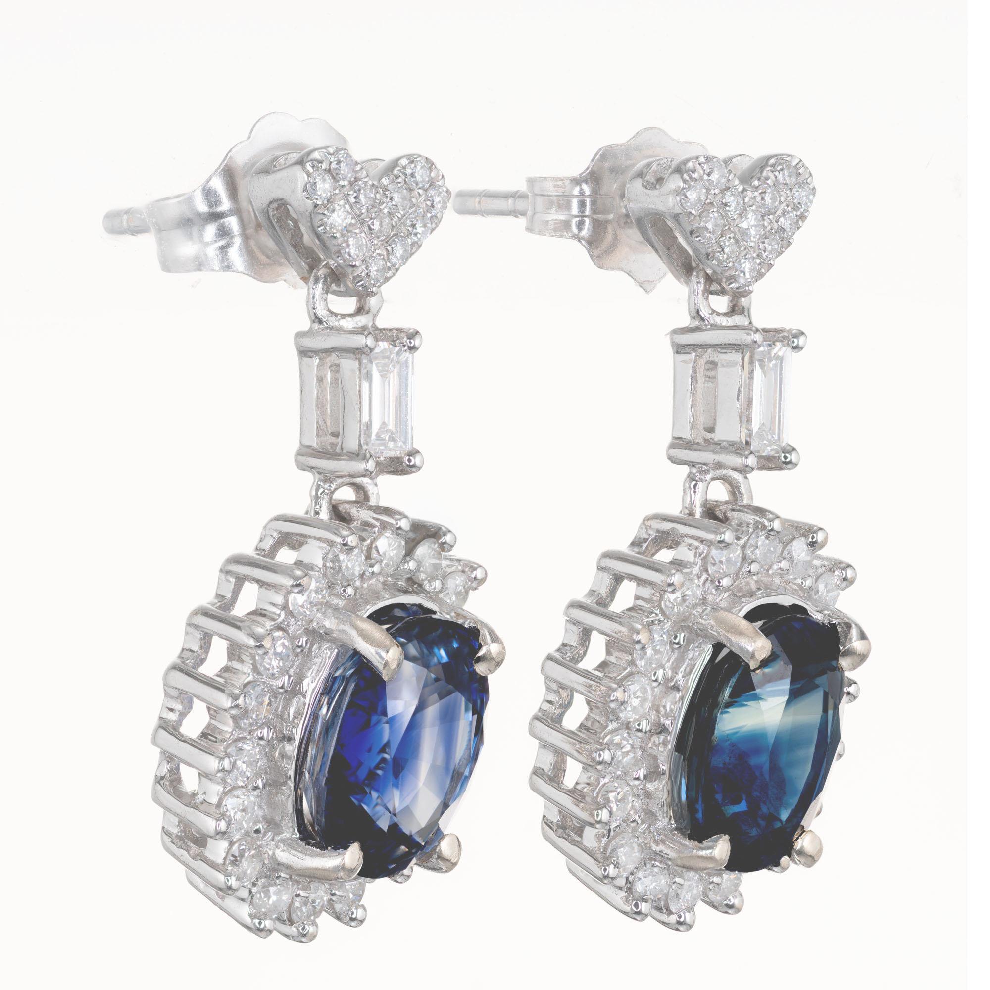 Sapphire and diamond halo dangle earrings with natural GIA certified simple heat only oval Sapphires and halo of full cut Diamonds, in 14k white gold. The top is a small micro pavé heart with a baguette separator. 

2 oval blue Sapphires, approx.