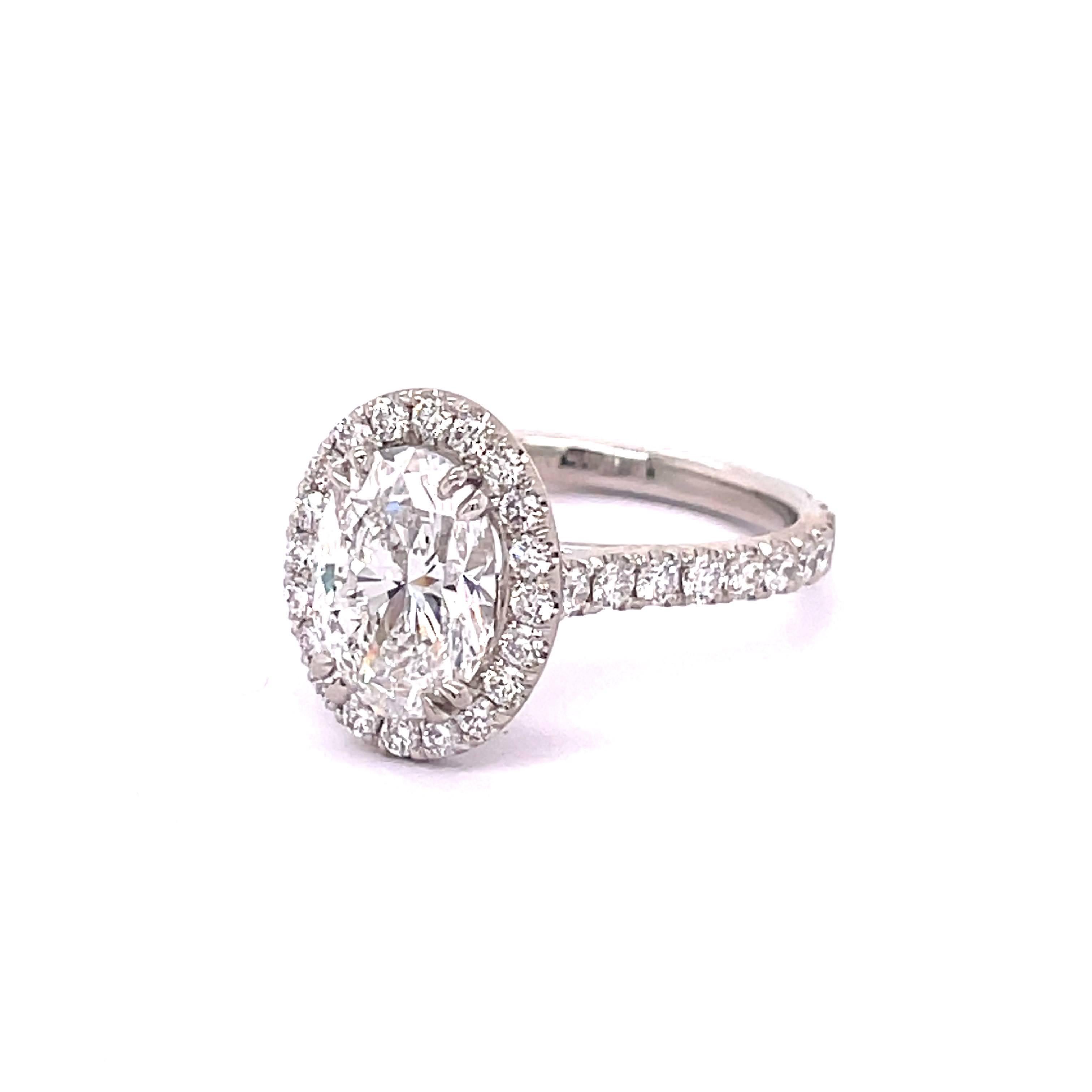 GIA Certified Oval Shape Diamond 2.20, D Color SI1 Clarity mounted elegantly on a Platinum setting filled with 0.94 round diamonds on its halo and shank making it even more special. A ring made to its perfection.
