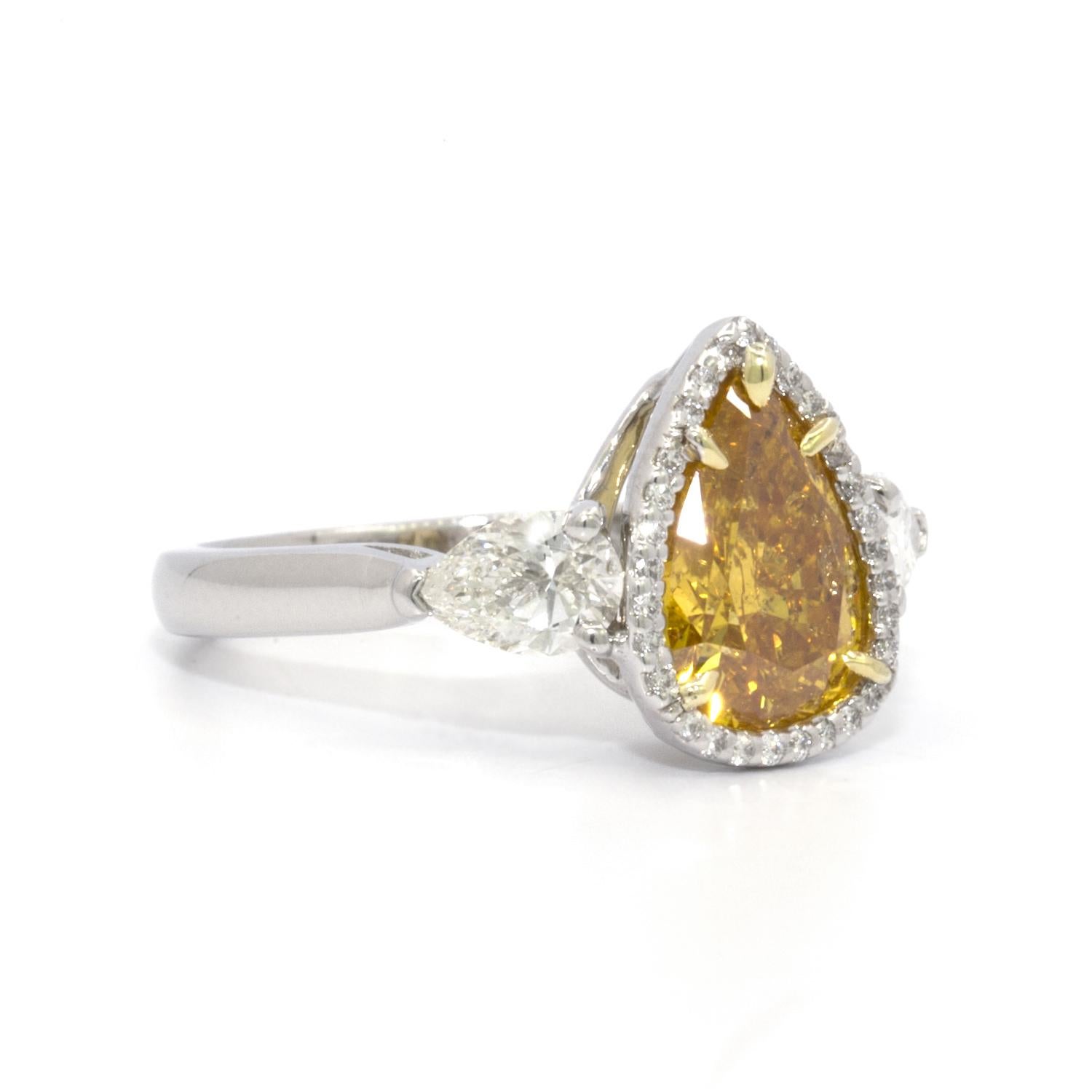 This GIA certified 2.20 ct Pear Brilliant Vivid Yellow-Orange Diamond is a truly unique ring. The brilliant cut and the brightness of the yellow color, combined with the warmth of the orange color make this diamond uniquely beautiful. GIA report