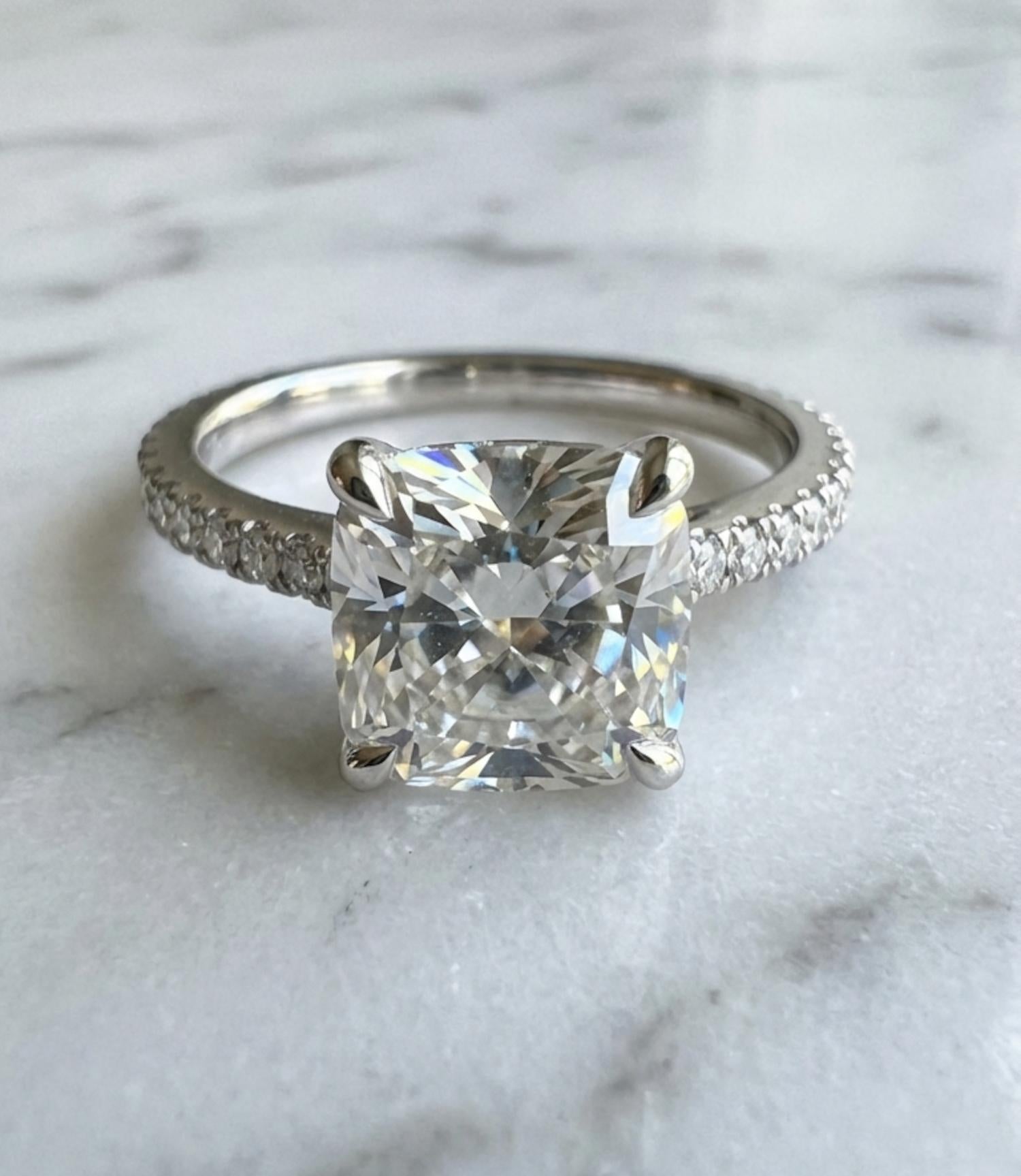 Cette élégante bague de fiançailles en platine est ornée d'un superbe diamant brillant modifié coussin de 2,21 carats, certifié par le GIA avec la prestigieuse couleur D et la pureté VS2.
La pierre présente une luminosité et une symétrie