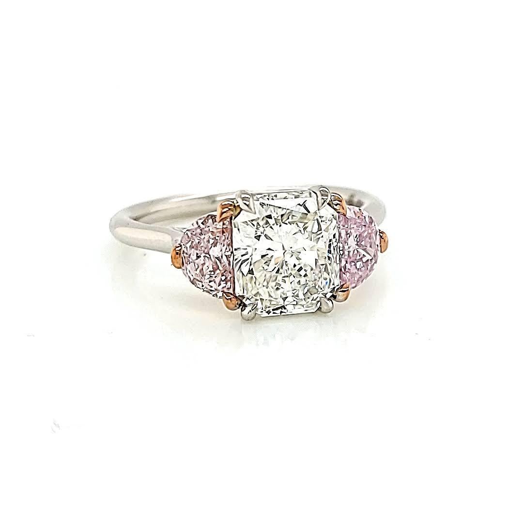Handmade 3-stone ring featuring a 2.21 Radiant, G-VS2. GIA#: 13090859. Accented by 2 fancy light pink, half-moon diamonds. GIA#'s