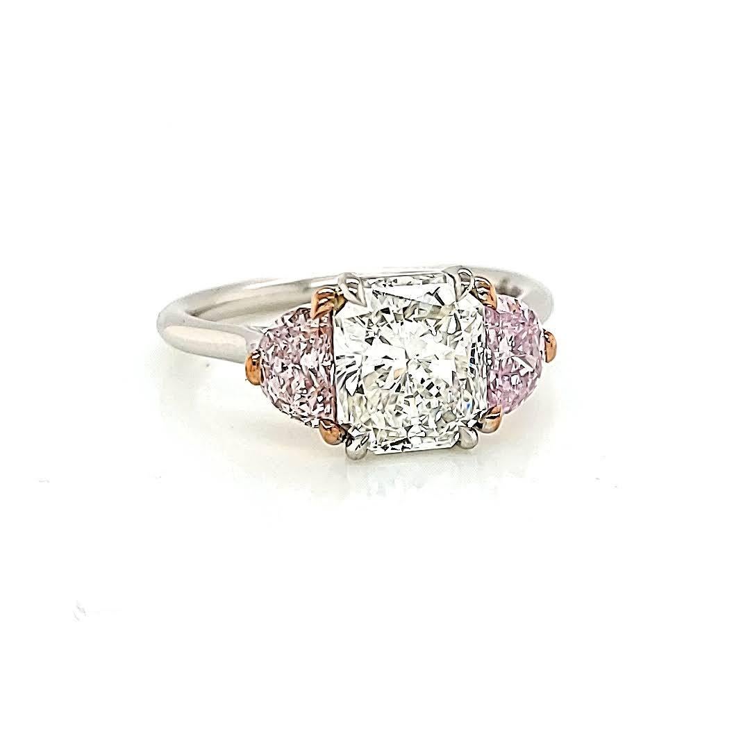 Anillo de 3 piedras hecho a mano con un radiante de 2,21, G-VS2. GIA#: 13090859. Acentuado con 2 diamantes de fantasía rosa claro en forma de media luna. GIA#'s