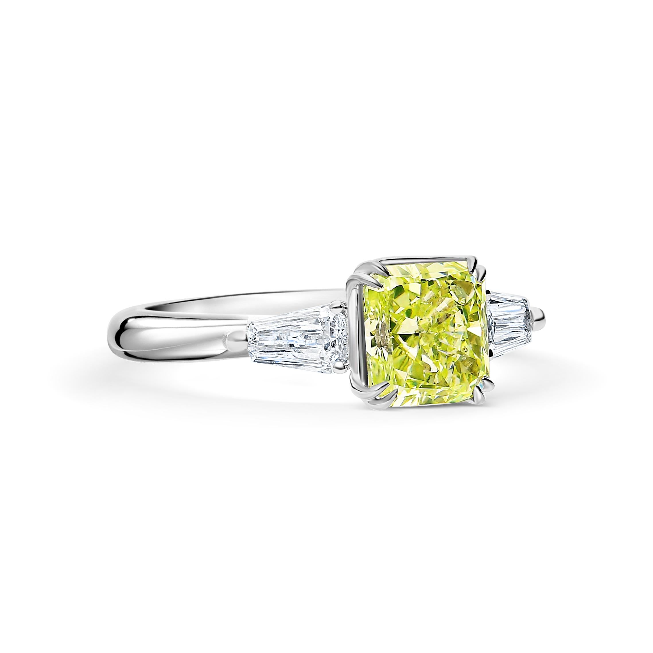GIA certified 2.22 carat fancy yellow-green radiant cut diamond three-stone ring. Featuring two flawless tapered baguette-cut diamonds. The center stone is a certified Fancy Yellow-Green, meaning that the predominant color displayed is green, with