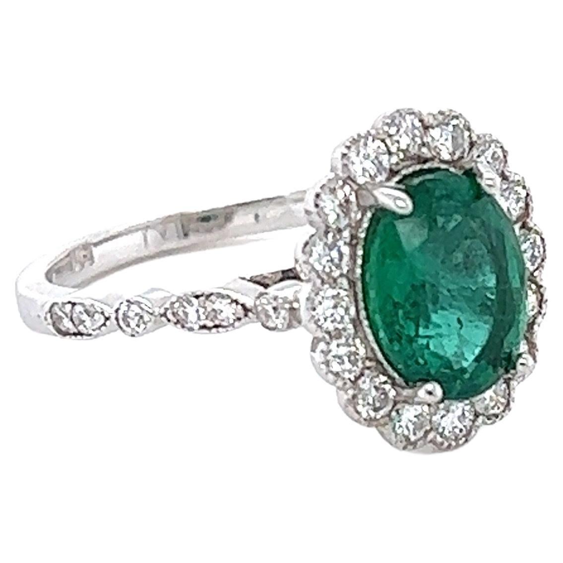 This ring has a 1.68 Carat Oval Cut Emerald and is surrounded by 28 Round Cut Diamonds that weighs 0.54 Carats. (Clarity: SI1, Color: F) The total carat weight of the ring is 2.22 carats. 
The Oval Cut Emerald measures at approximately 9 mm x 7 mm.