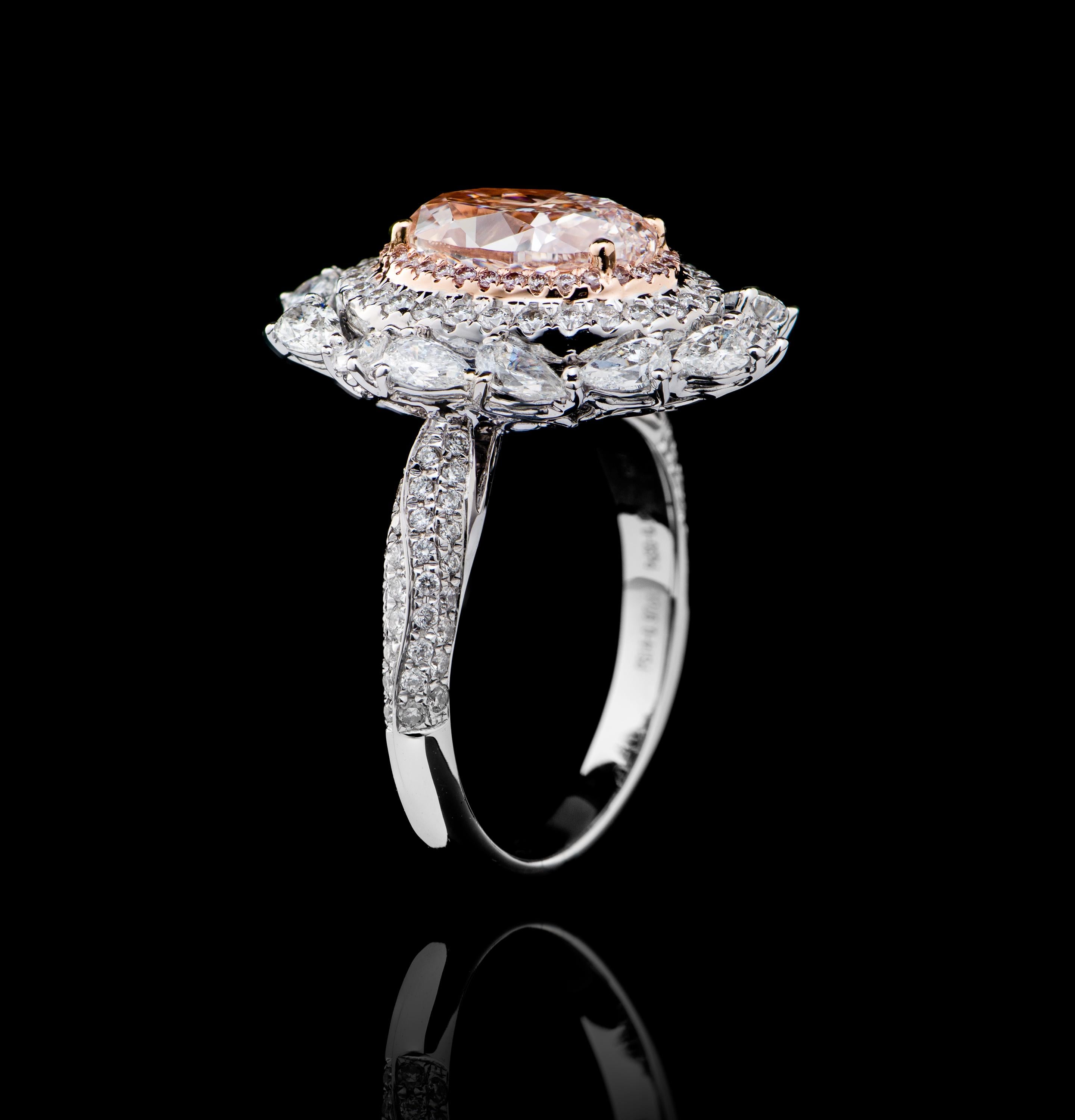 
This handcrafted ring is worthy of the hand of someone as equally special. 
It is beautifully showcased by a GIA certified  2.22 Carat  Natural Pink Oval Diamond, and is surrounded by a halo mounting of smaller pink diamonds.  The ring continues