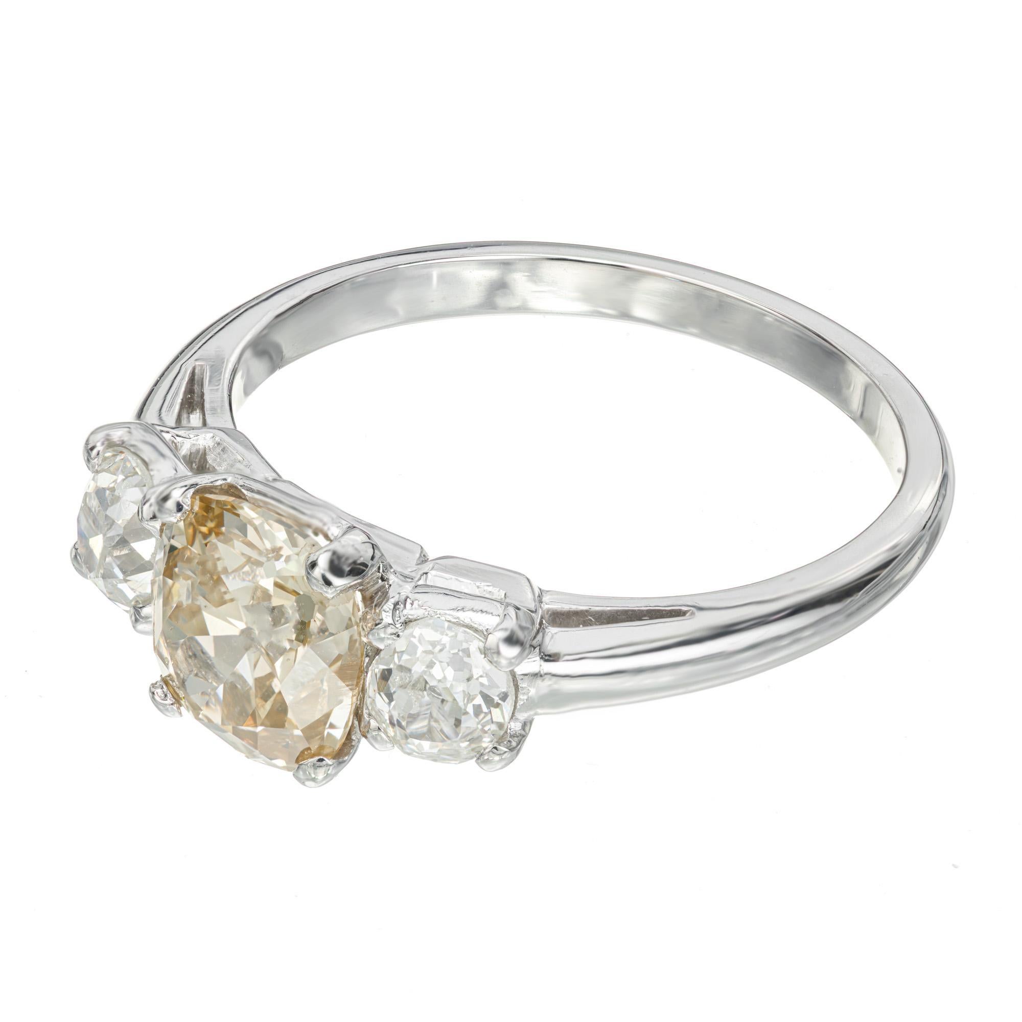 Turn of the century natural brown yellow diamond three-stone engagement ring. GIA certified Center stone set in platinum setting with 2 old mine white side diamonds. The center is an untreated natural fancy golden yellow 1.58ct old mine brilliant