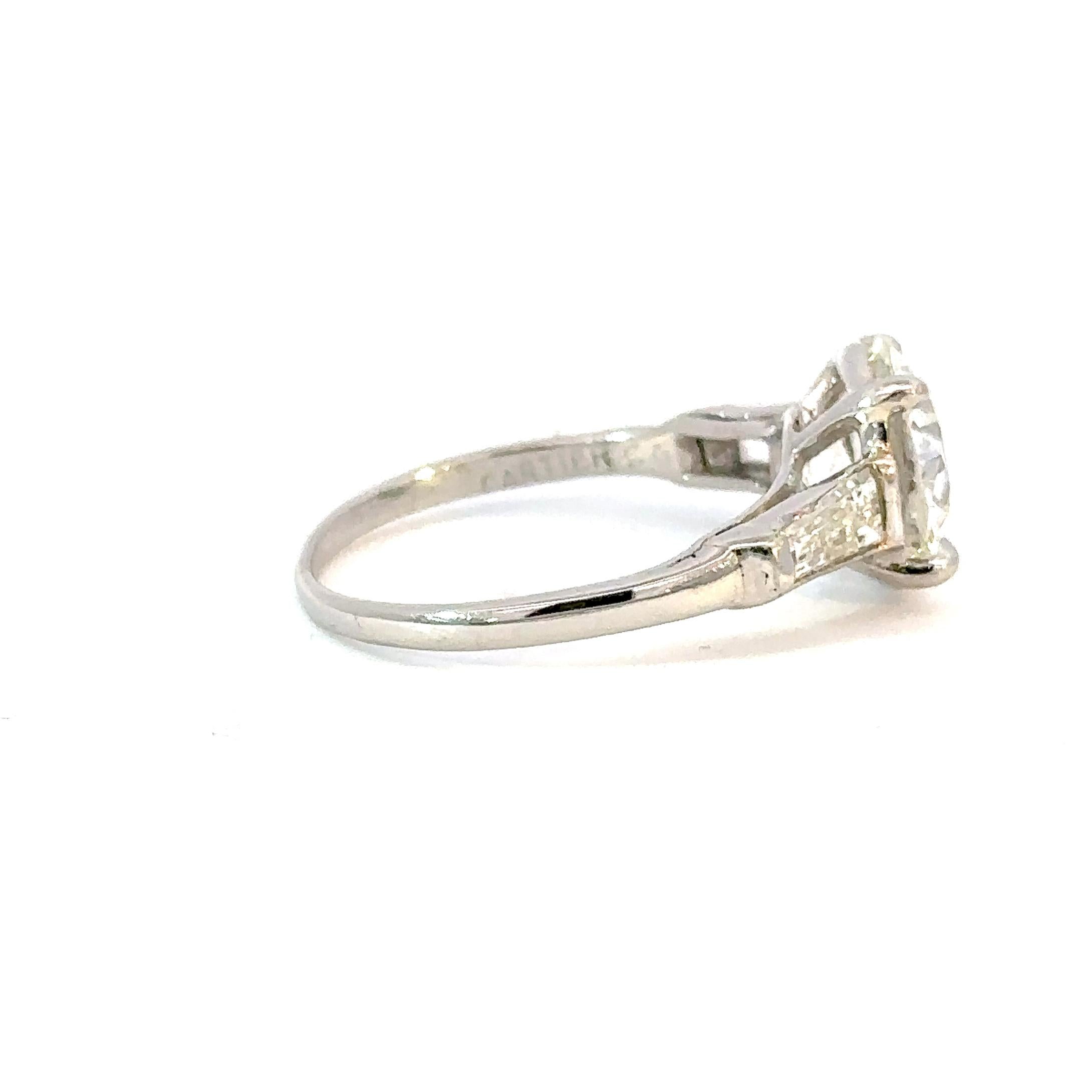 A heirloom quality diamond engagement ring crafted in the Art Deco era by Cartier.
The timeless design of the palladium setting showcases two baguette diamonds of the highest quality on each side of the main diamond.
The diamond I chose for this