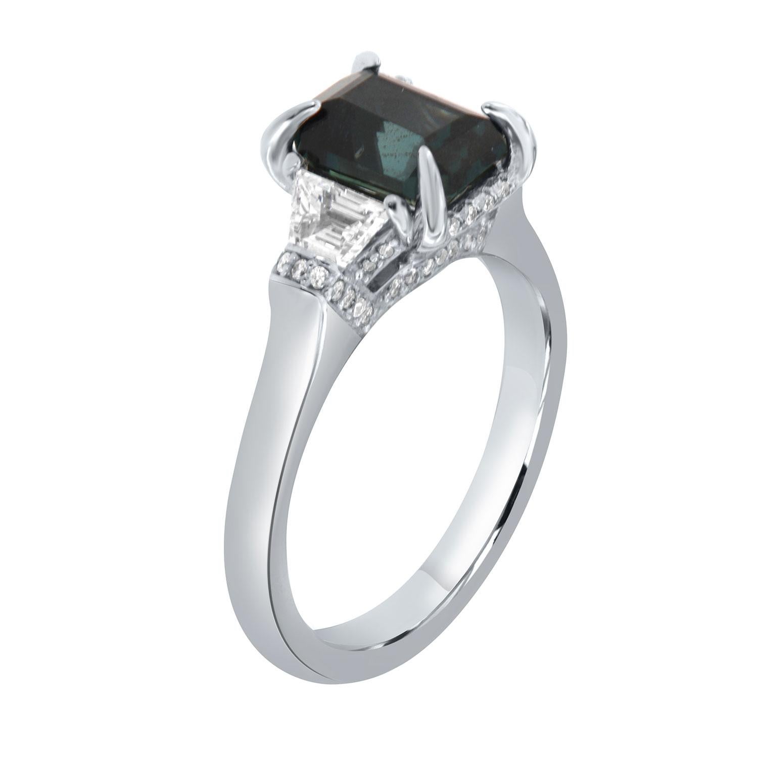 This Hand-Crafted stunning ring features 2.3- Carat emerald shaped Non-Heated dark blue Natural sapphire GIA Certified encircled by a hidden halo of delicate diamonds Micro-Prong set. The sapphire is flanked by two perfectly matched Trapeze-shaped