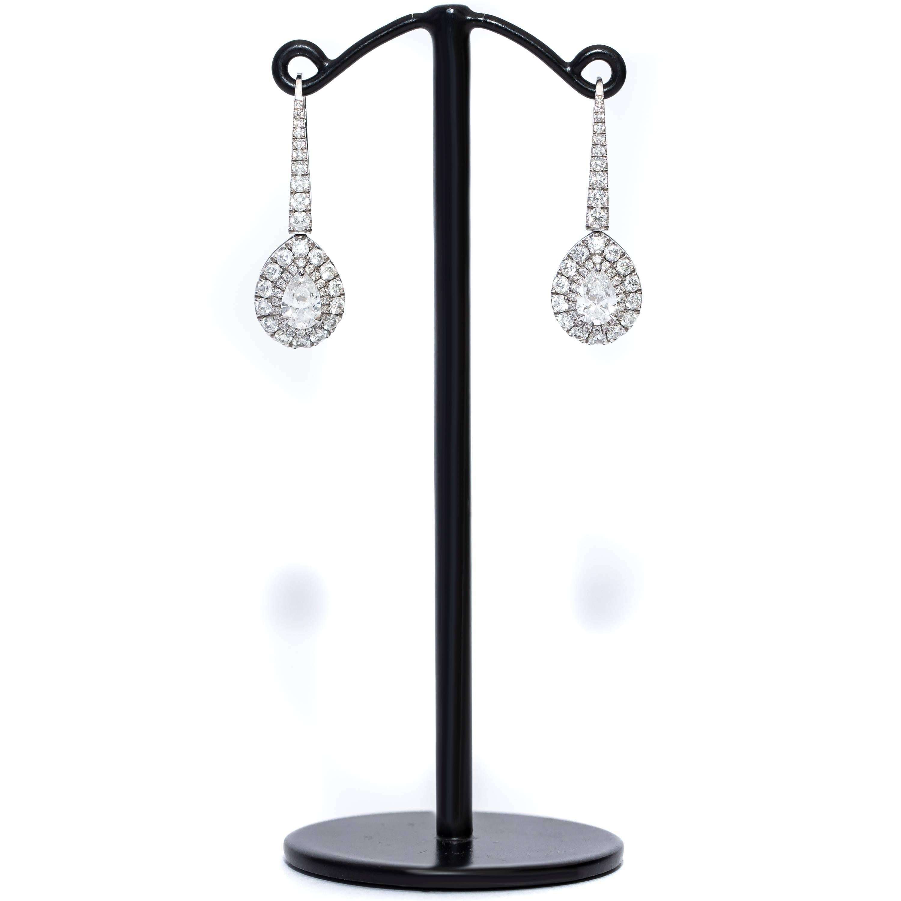 These Beautiful GIA Certified Diamond Pear Shaped Drop Halo Earrings feature 2 GIA Pear Brilliant Diamonds D-VS1 in the center both weighing 0.50 Carat each surrounded by 1.30 Carat Color H Clarity SI1 Round Brilliant Diamonds on the Halo and