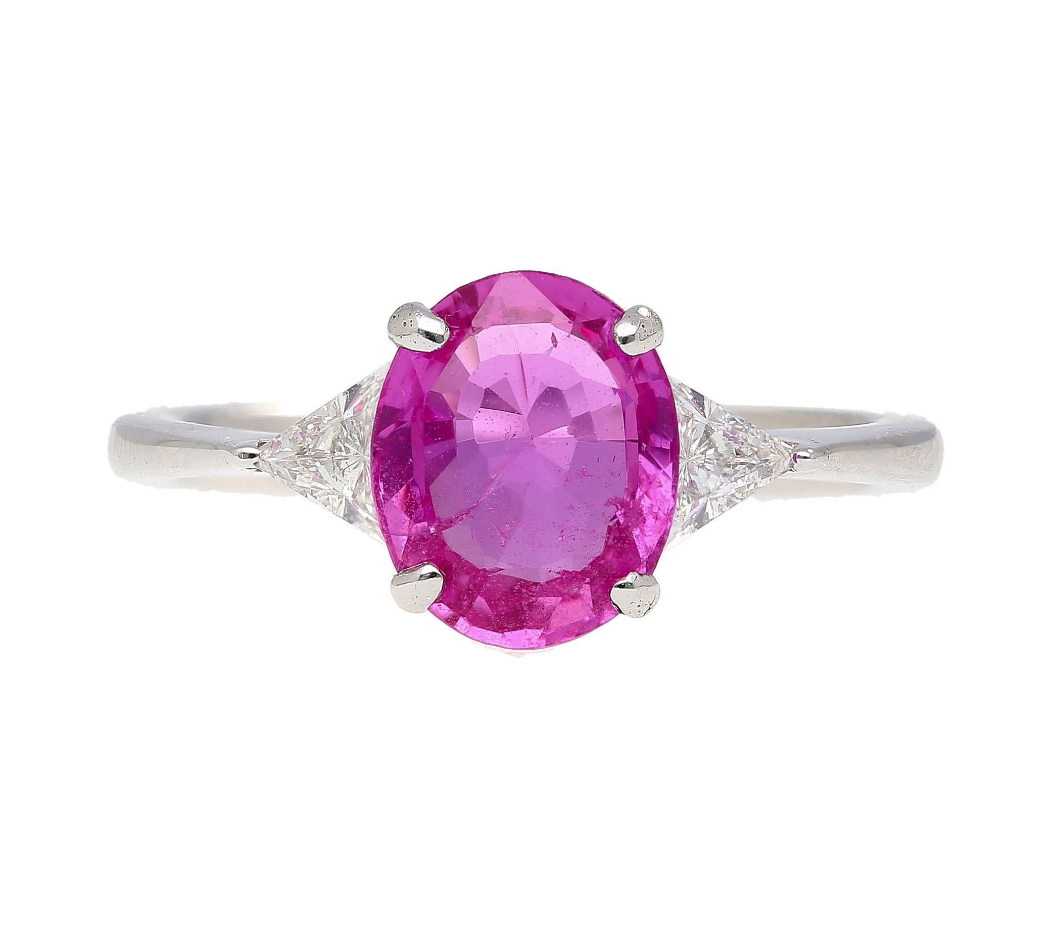 GIA Certified 2.31 carat oval cut pink sapphire ring flanked by brilliant trillion-cut diamonds in an 18k white gold three stone engagement ring. Ring size 6.5, adjustable.

Details
Item Type: Engagement Ring
Metal: 18K White Gold
Weight: 2.88