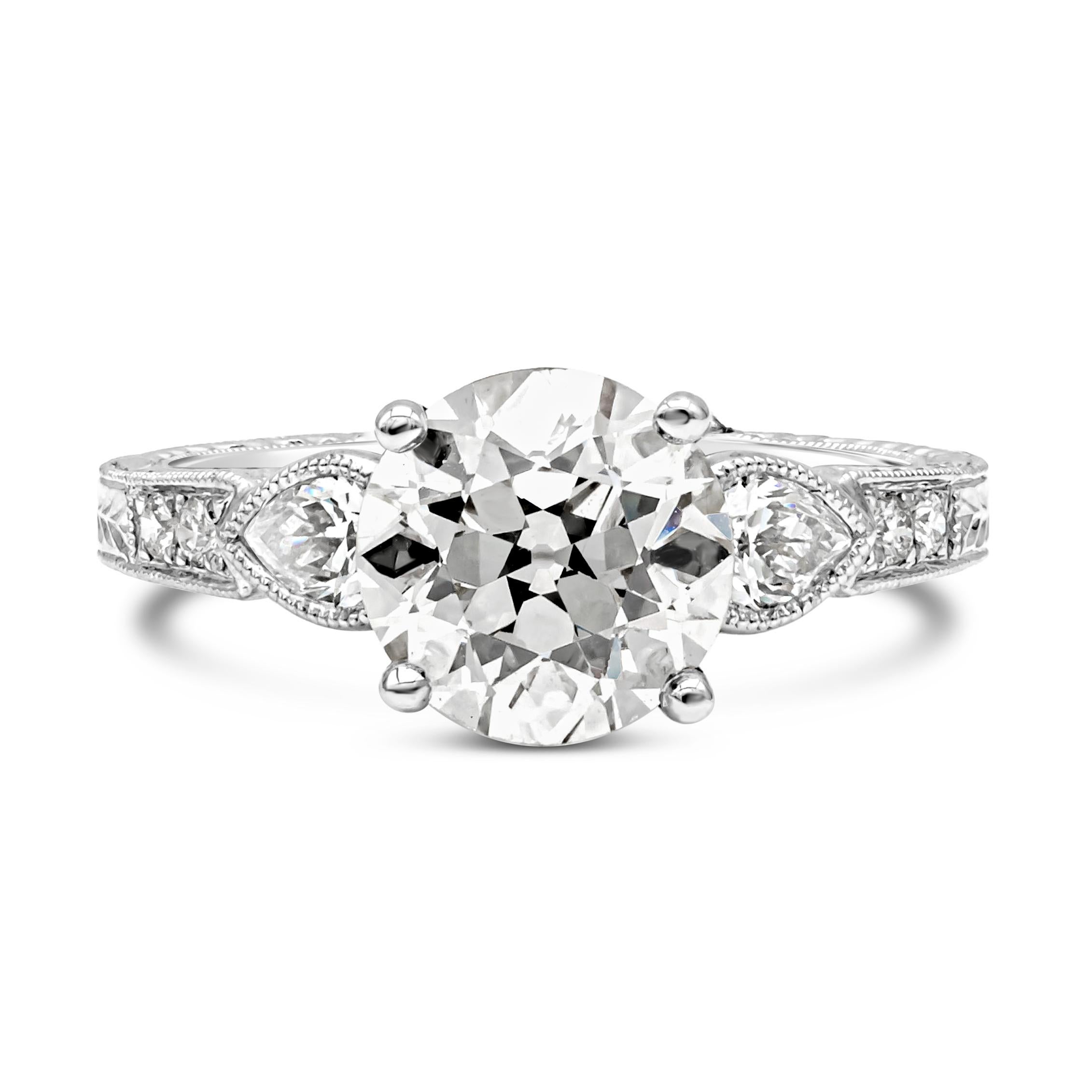 An antique-style diamond engagement ring showcasing a 2.31 carats old European cut diamond certified by GIA as M Color and VS1 in Clarity. Flanking the center are pear shape diamonds weighing 0.34 carats total, set in an 18k white gold bezel with