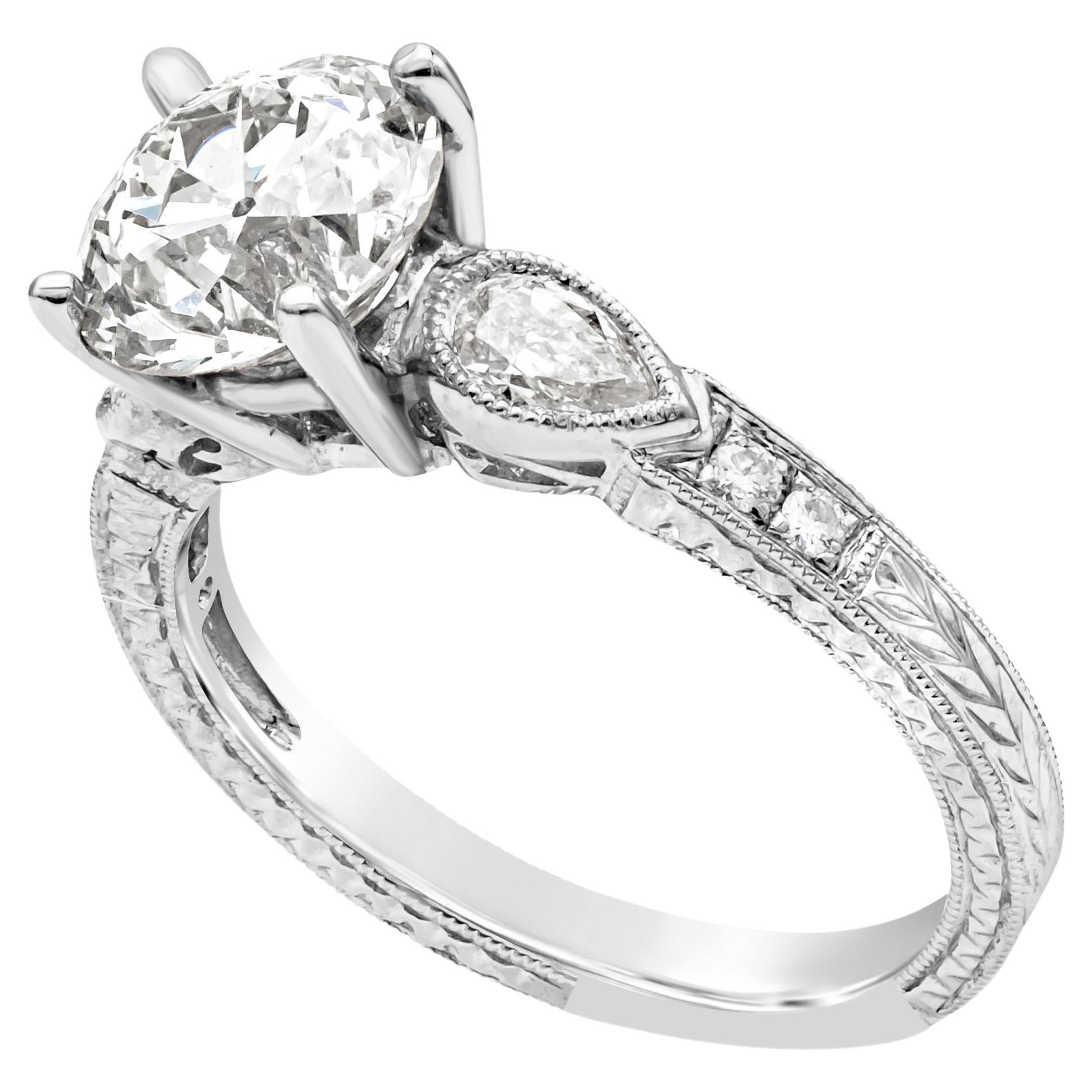 Anillo de compromiso de estilo antiguo, con un diamante de talla europea antigua de 2,31 quilates, certificado por el GIA como de color M y claridad VS1, engastado en una montura de cuatro garras. Flanqueada por diamantes en forma de pera con un