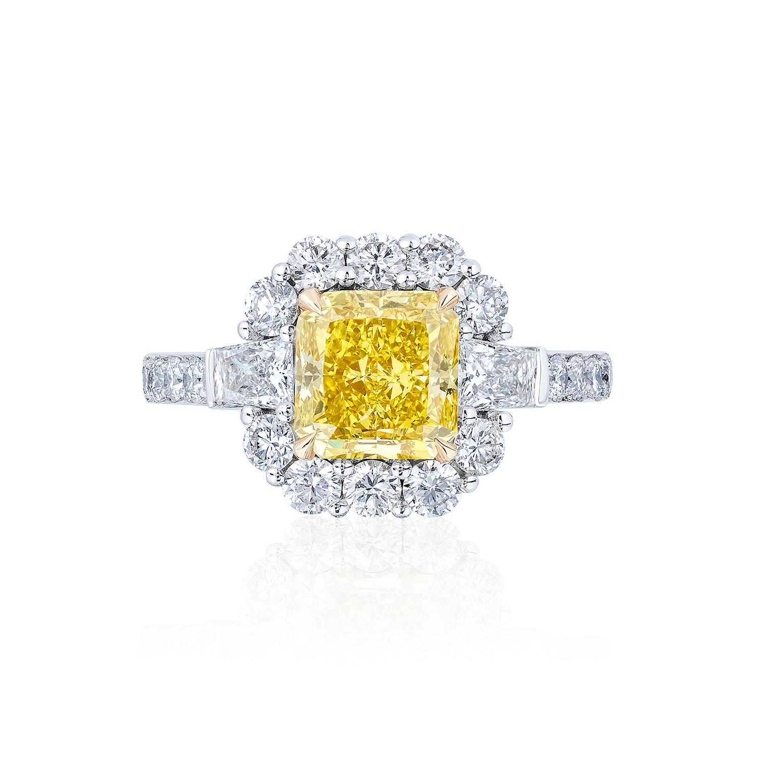 2.38 Carat Fancy Vivid Yellow Diamond flanked by Brilliant cut tapered baguettes and surrounded by Round Brilliant Diamonds.

Certified by GIA and Set in platinum and 18 Karat Yellow Gold.