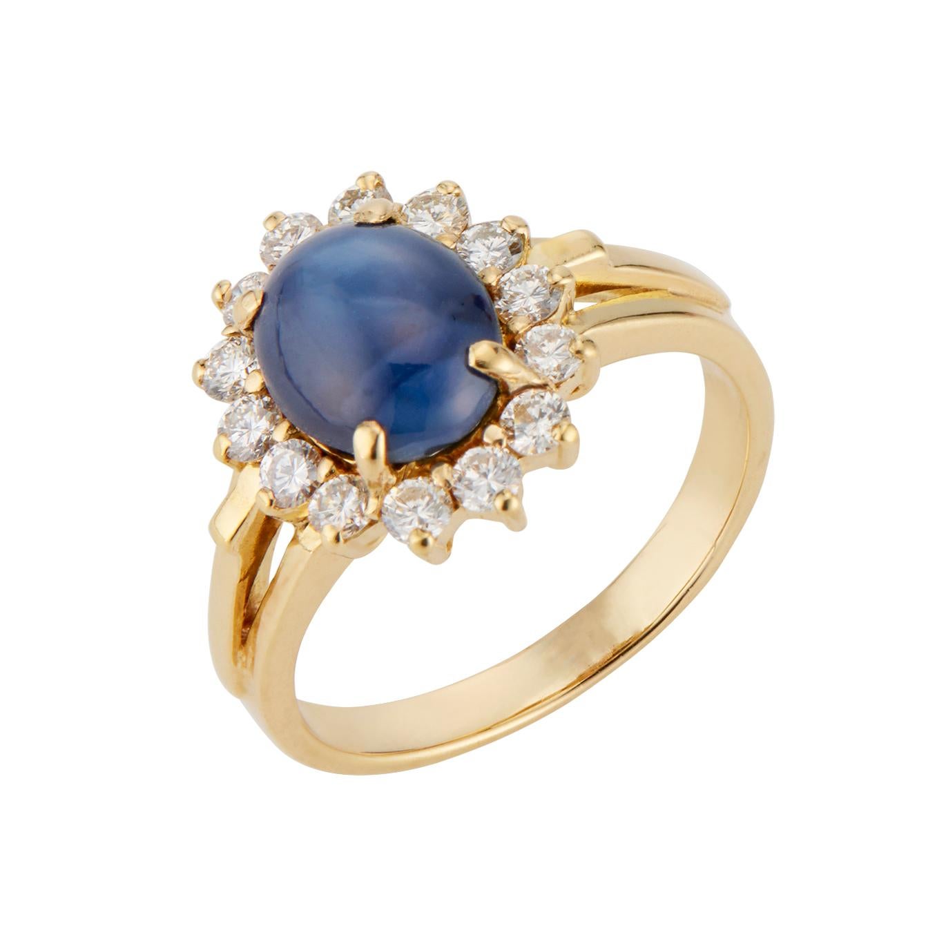 Sapphire and diamond engagement ring. GIA certified 2.34cts oval star sapphire with a halo of 14 round diamonds in a 18k yellow gold setting. Circa 1960's. 

1 oval cabochon blue Sapphire, approx. total weight 2.34cts, natural, no heat, GIA