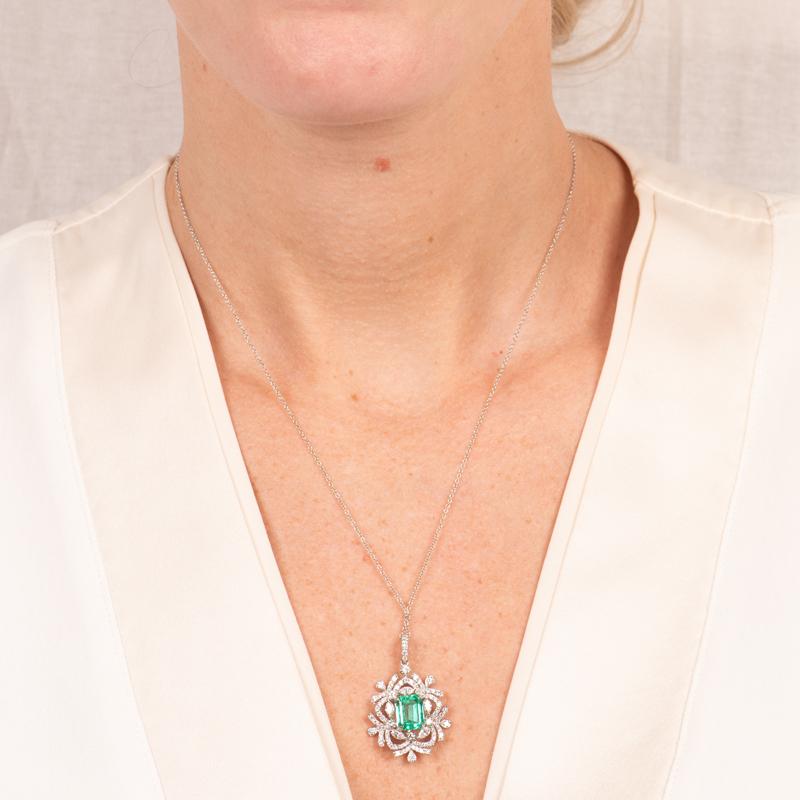 This beautiful pendant necklace features a 2.38 carat emerald cut natural Colombian emerald accented by 1.80 carat total weight in round brilliant and marquise shaped diamonds set in 18 karat white gold. It is set on an 18 karat chain measuring 18