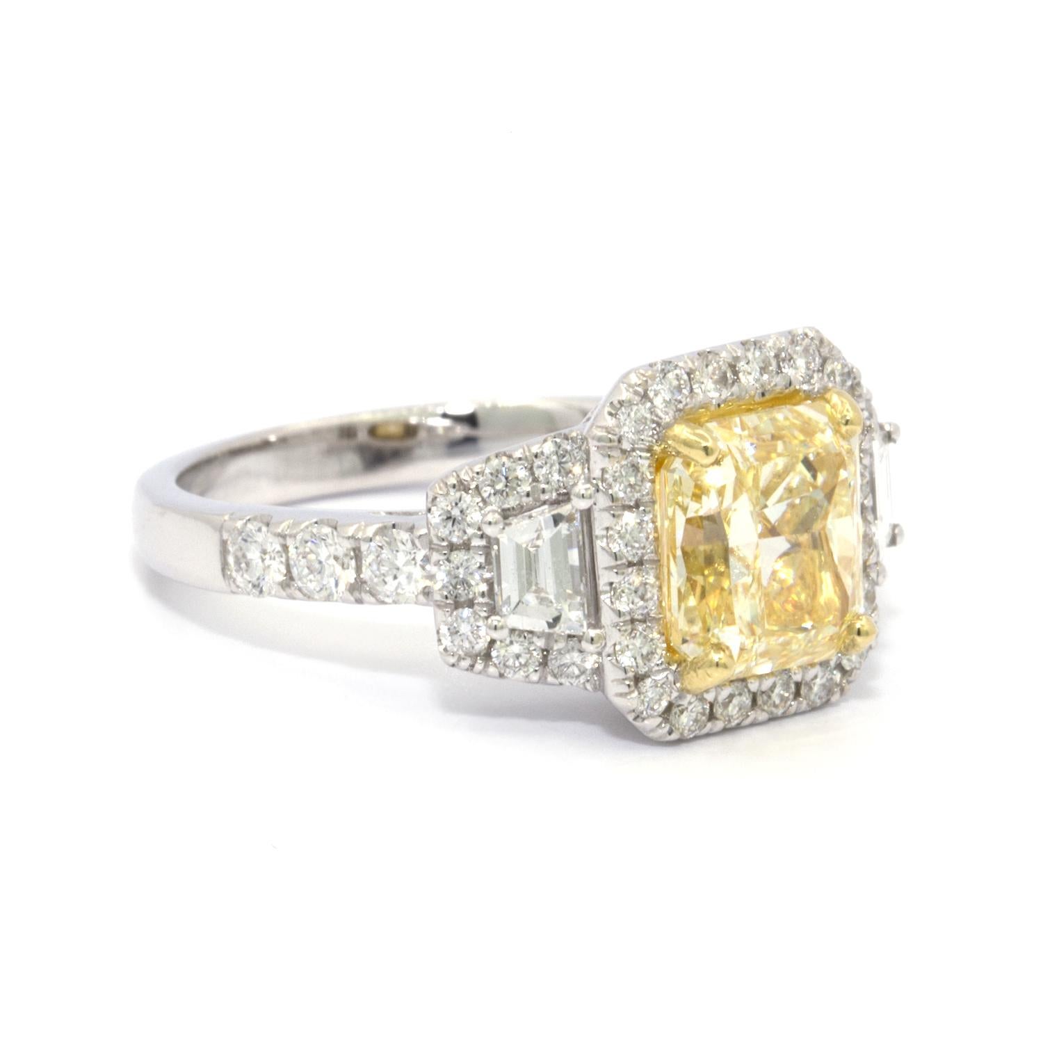 GIA Certified 2.39 ct Radiant Cut Fancy Yellow Diamond Ring set in a 18k white gold  that has been stamped stamped Ed.B. This filigree white gold ring is set with 26 RBC and 2 trapezoid shaped white diamonds that weigh approximately 1.16 cts.. The