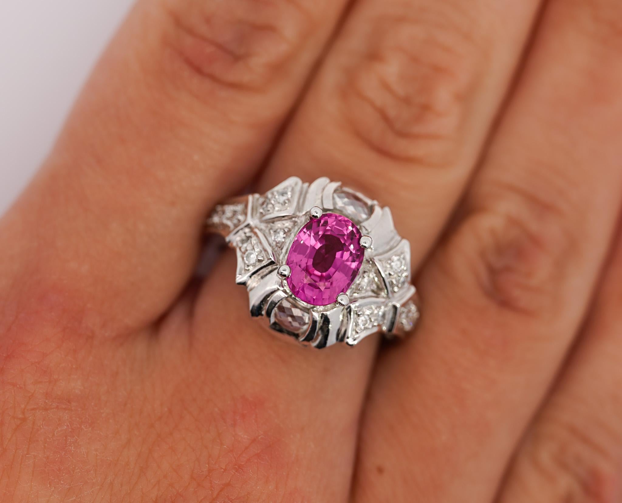 GIA Certified Pink Sapphire and Diamond Ring. 

Crafted and set in platinum, this engagement ring features a sapphire center stone. The sapphire radiates a purplish pink hue and weighs 2.40 carats. It is GIA certified and originates from Madagascar,