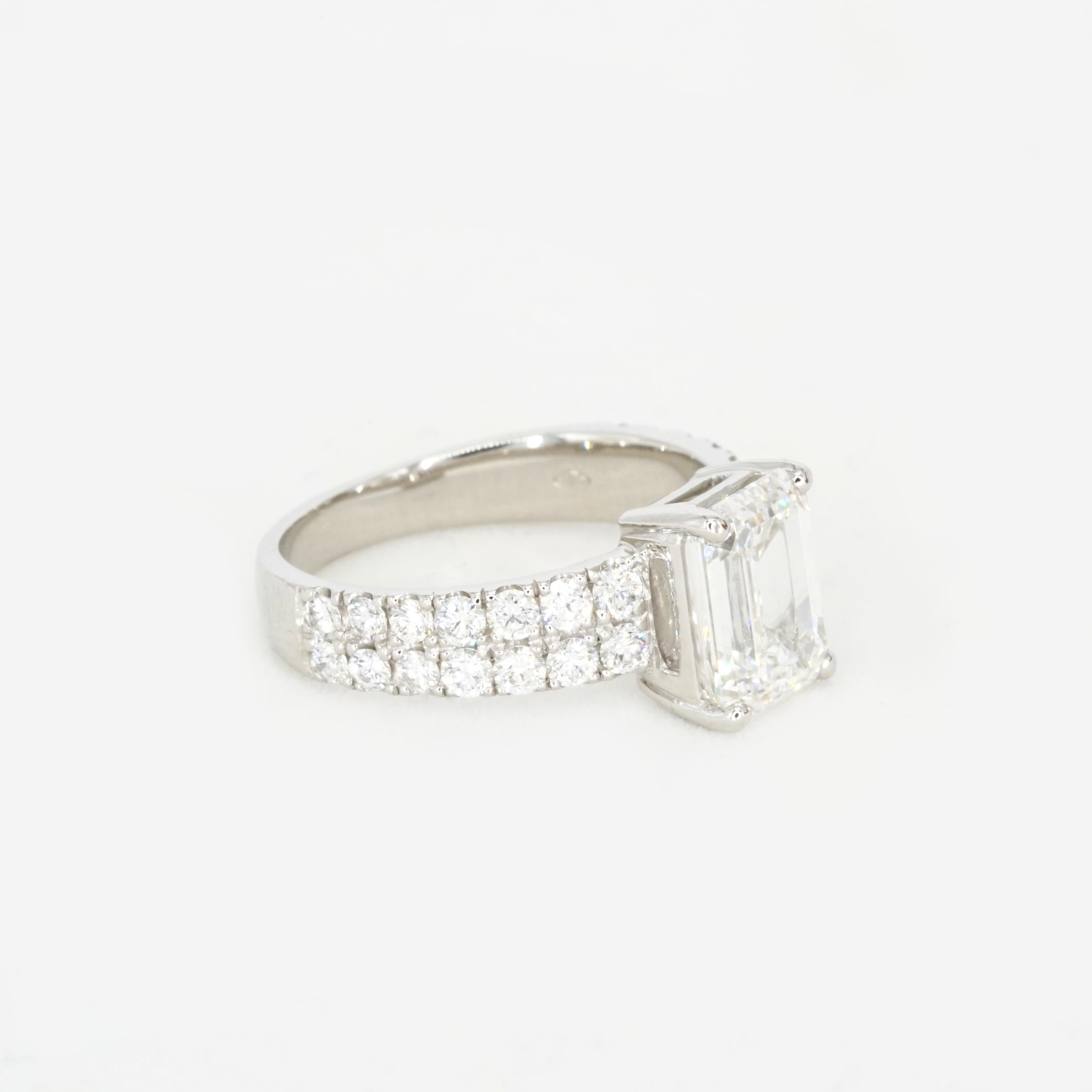 Showcasing a 2.50 carat emerald-cut diamond of exceptional F color and VS1 clarity (GIA Certified), this elegant engagement ring is crafted in 18K white gold. The center stone’s clean lines and radiant fire are complemented by a pavé-set band of