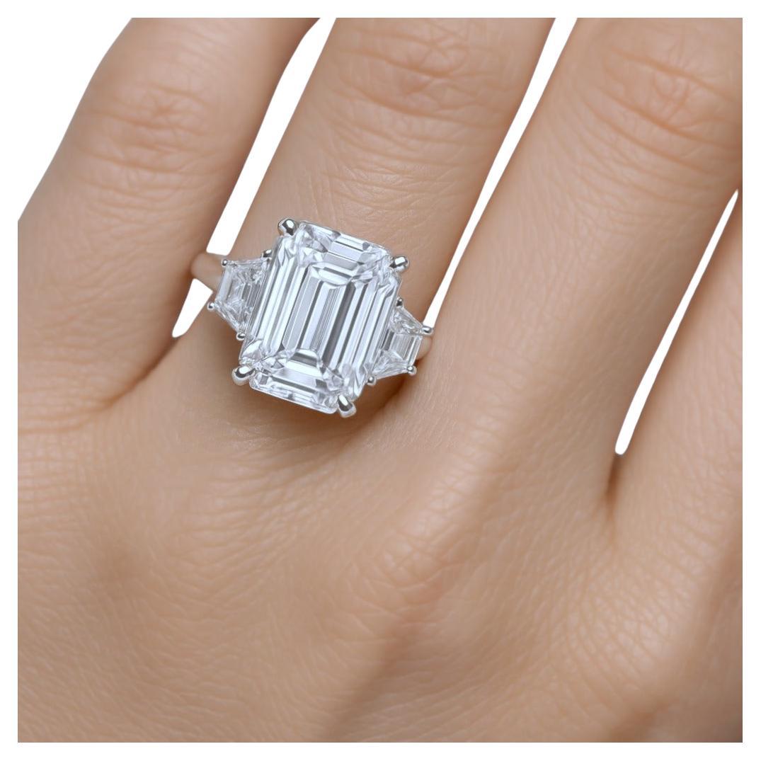Questo splendido anello in platino mette in mostra un notevole diamante con taglio a smeraldo da 2.50 carati come pezzo centrale, affiancato da diamanti trapezoidali splendidamente abbinati su entrambi i lati, creando un design sofisticato ed