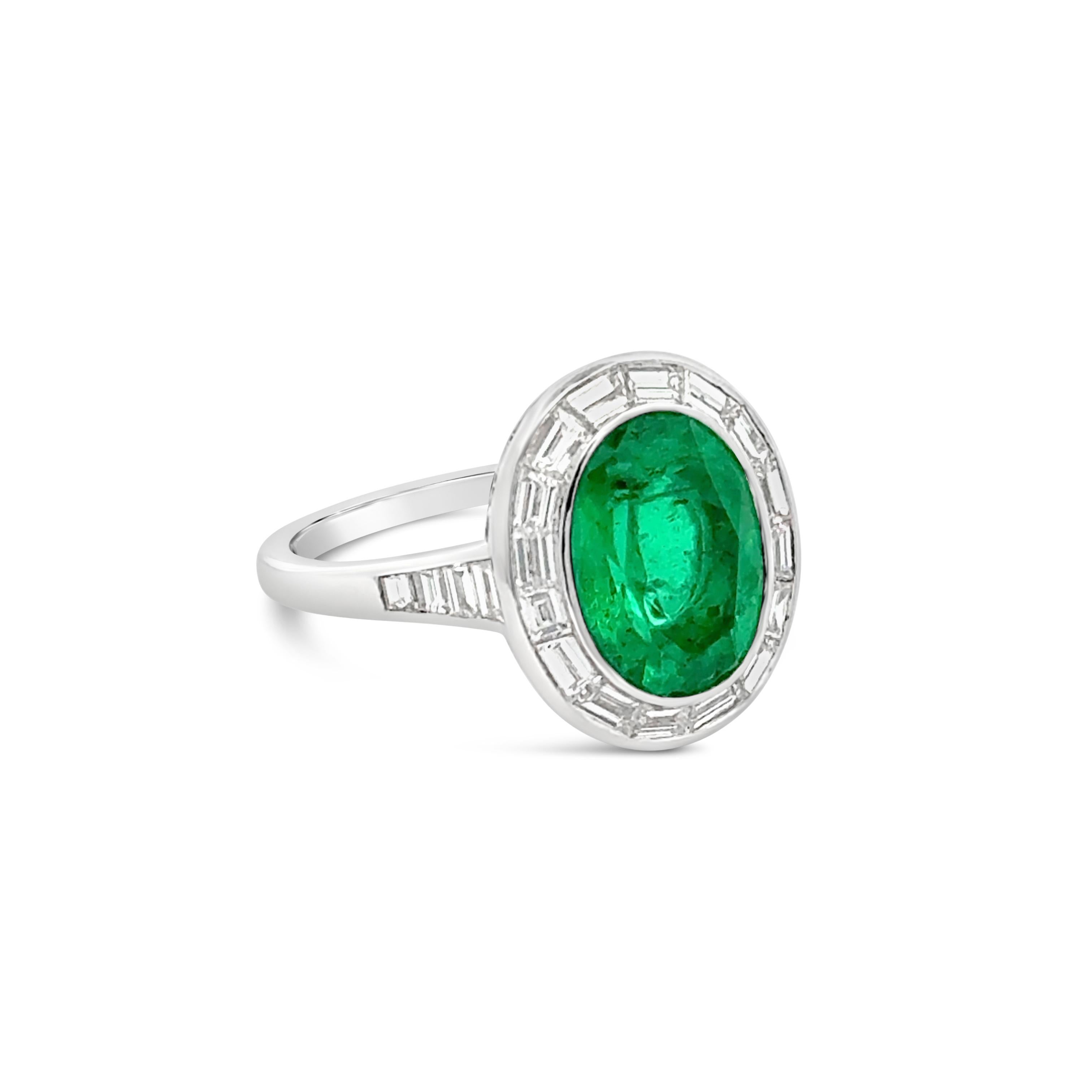 A beautiful engagement ring, featuring a 2.51 carats oval cut Colombian emerald, bezel-set in a platinum mounting. Surrounded by a halo channel-set baguette cut diamonds and accented by a diamond encrusted shank in a half-way setting. Accent