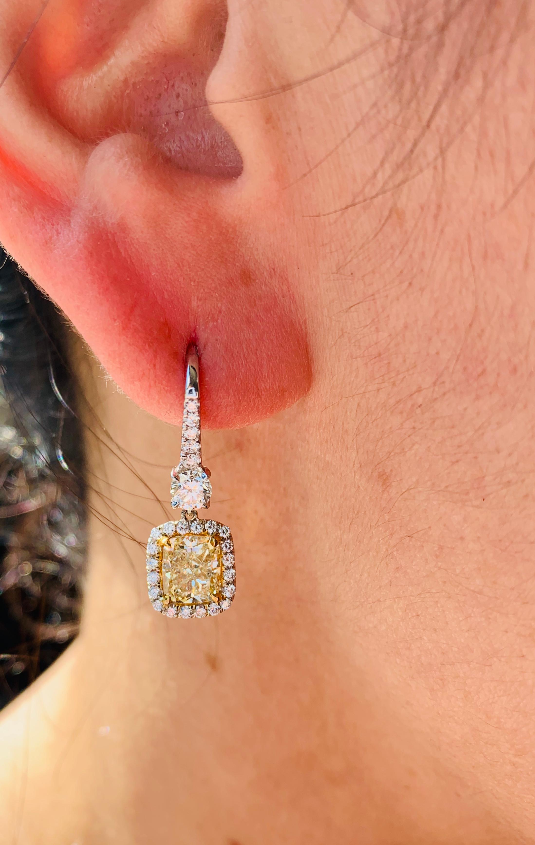 Stunning Yellow Diamond Earrings, certified by GIA laboratory features 2.53 Carats of Fancy Light Yellow Cushion Cut diamonds, SI in Clarity. 
GIA#2175791322
GIA#1162644850
Two main yellow diamonds, surrounded by white brilliant cut diamonds