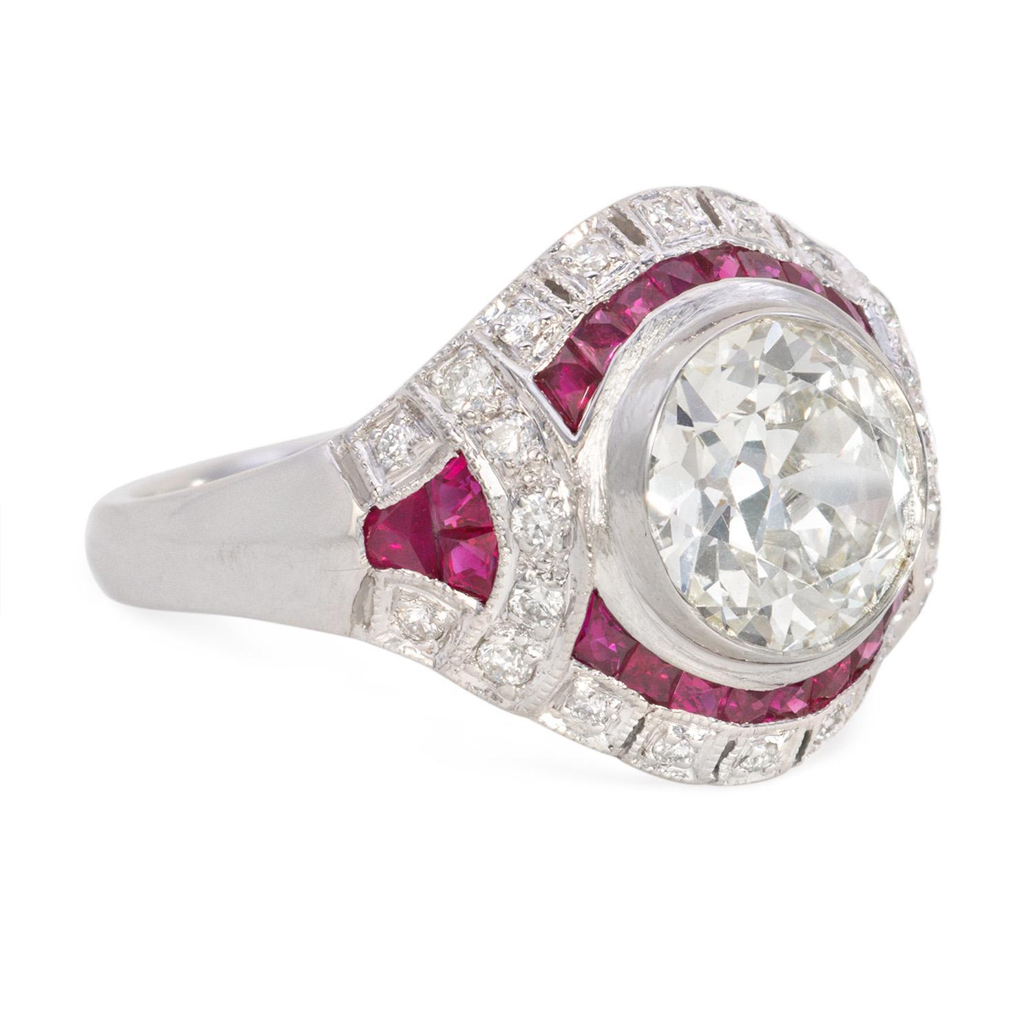 This stunning Art Deco ring features a GIA-certified 2.56-carat diamond with an N VS1 clarity. The center diamond is elegantly surrounded by 1.15 carats of vibrant rubies, adding a pop of color to the platinum setting. With a total diamond weight of