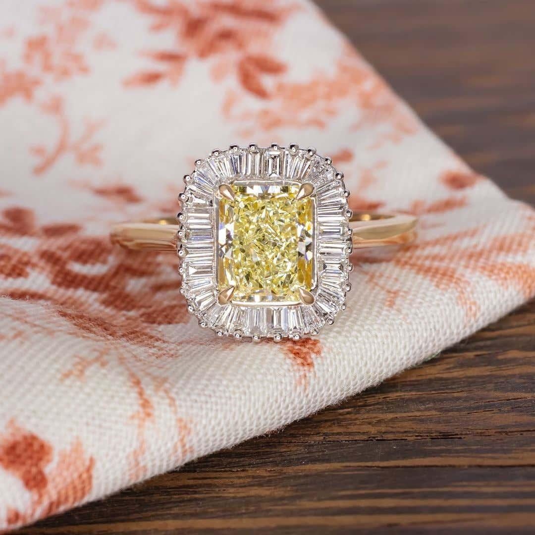 An exquisite fancy yellow diamond ring composed by a 2.56 fancy yellow radiant cut diamond and surrounded by a ballerina diamond setting mounted in 18 carats gold.