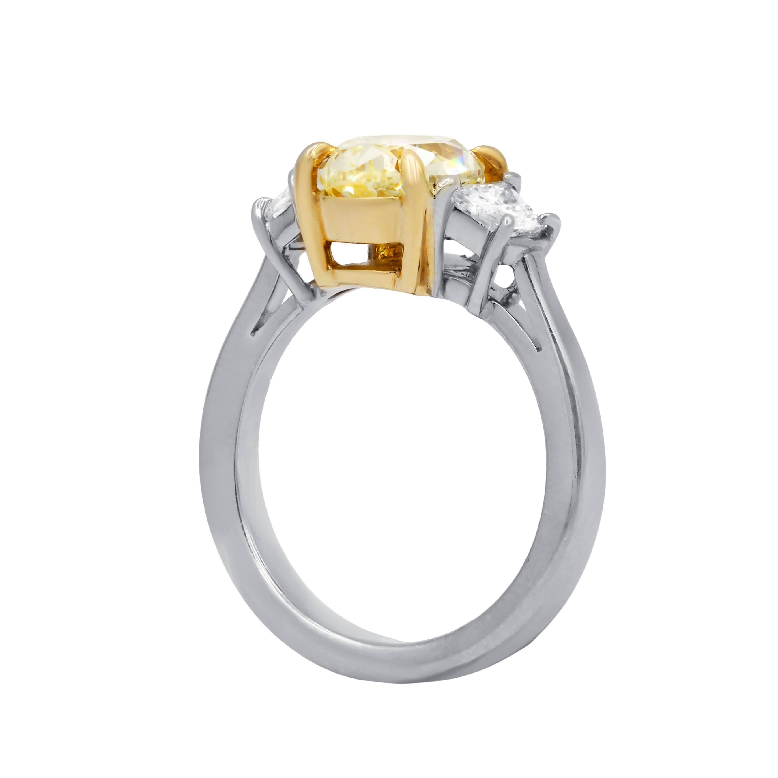 Beautiful designed diamond engagement ring in platinum mounting.The center GIA certified diamond features natural fancy yellow 2.58 cts oval modified brilliant cut diamond,VS1 clarity and accented by additional  0.75 cts white natural diamonds on