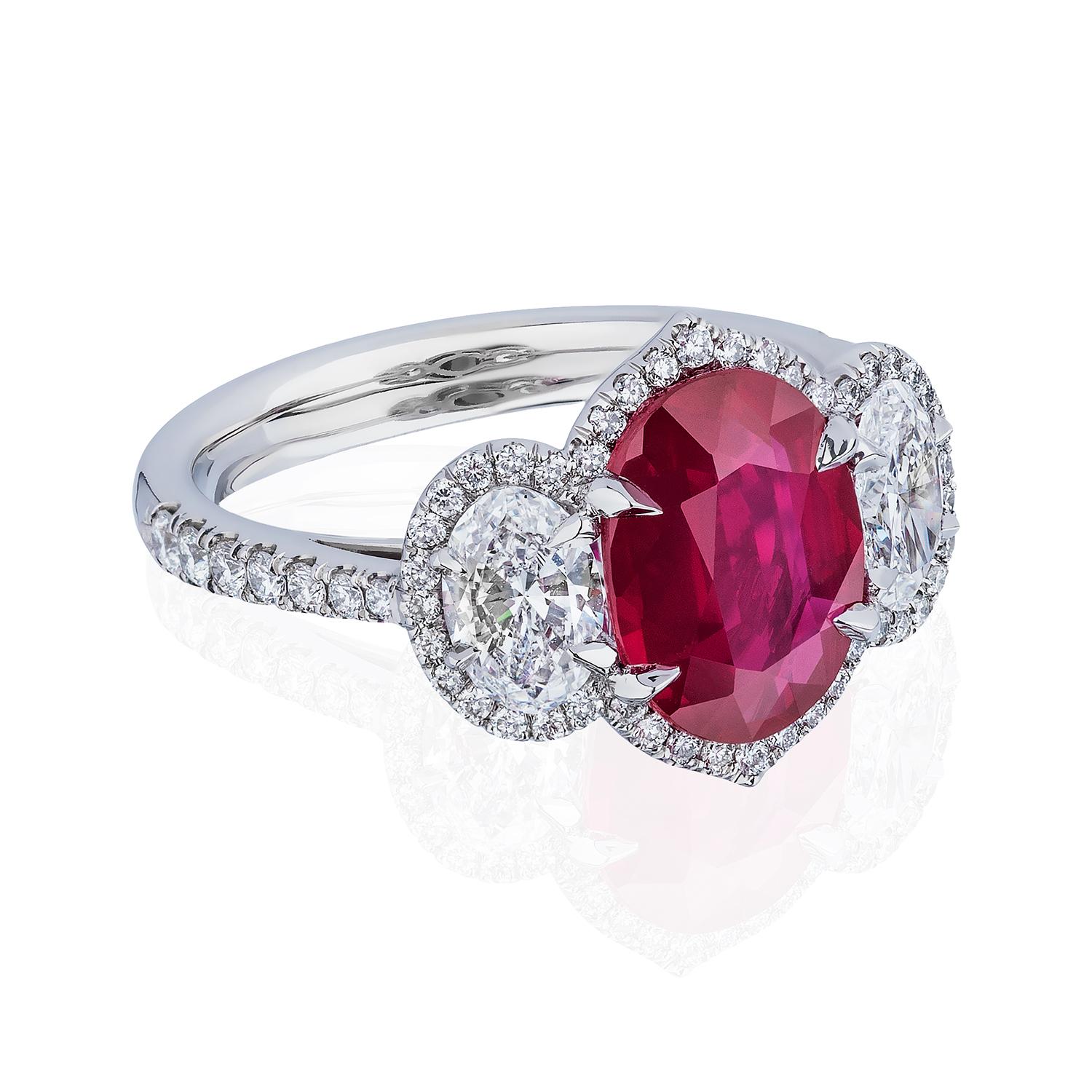 Unheated Ruby and Diamond Three Stone Ring

Gorgeous and highly sought Purplish Red Ruby weighing 2.61 Carats with No Heat Treatments flanked by 2 Oval Diamonds of D color and VS Clarity each weighing 0.40 Carats, surrounded with pave set Round