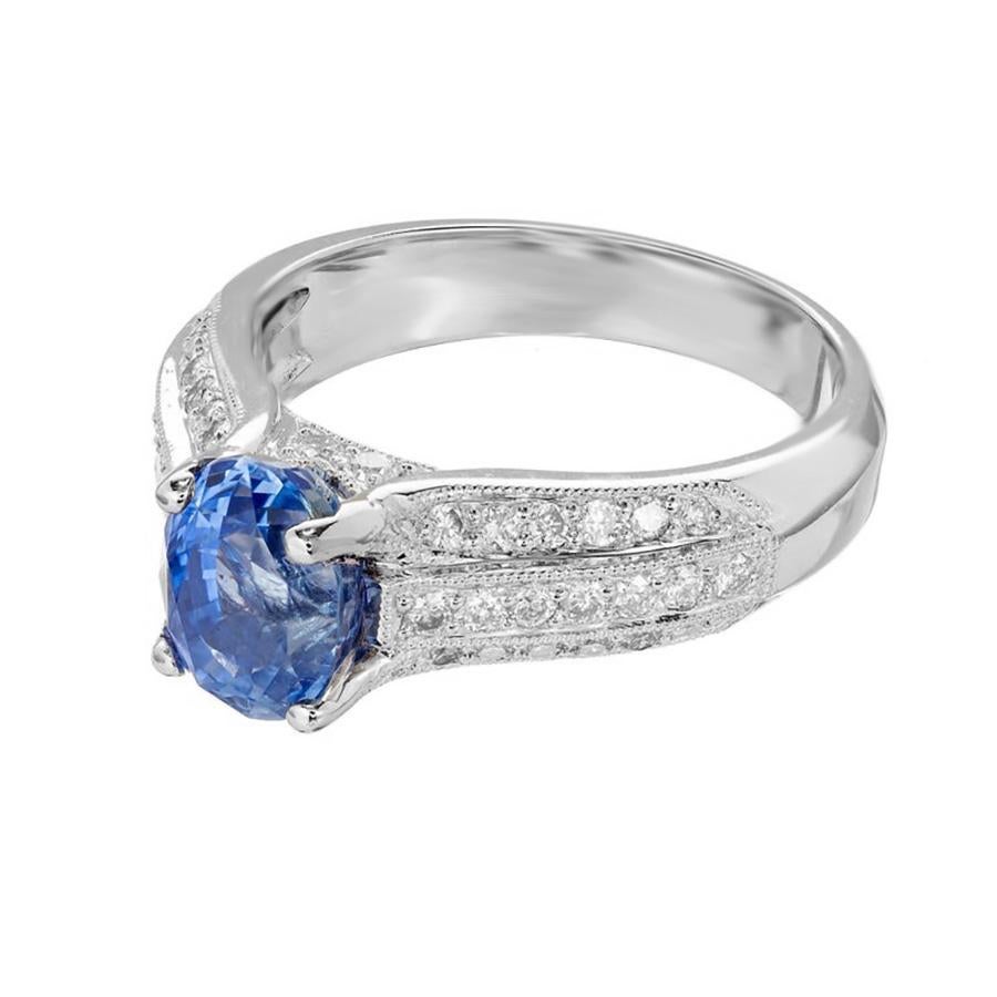 Bright blue oval Sapphire and round diamond engagement ring. The center is a 2.64ct oval sapphire, mounted in a 18k white gold setting that is adorned with three rows of round cut diamonds. The GIA has certified the gemstone as simple heat only. The