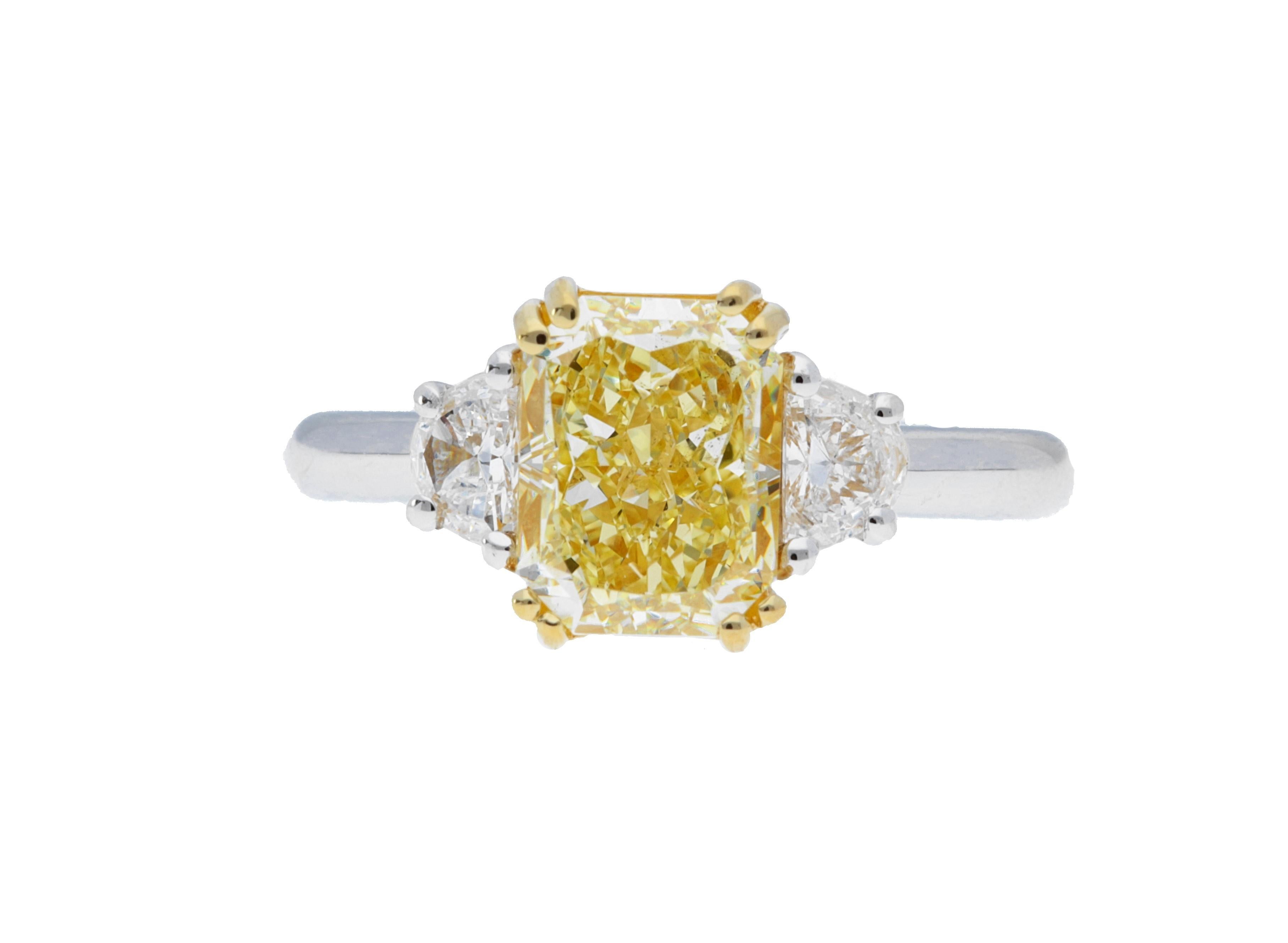 A Sofer Jewelry Original. GIA certified 2.29ct fancy yellow SI2 radiant diamond with two half-moon side stones weighing 0.38 carats total set in platinum and 18 karat yellow gold. Size 6.