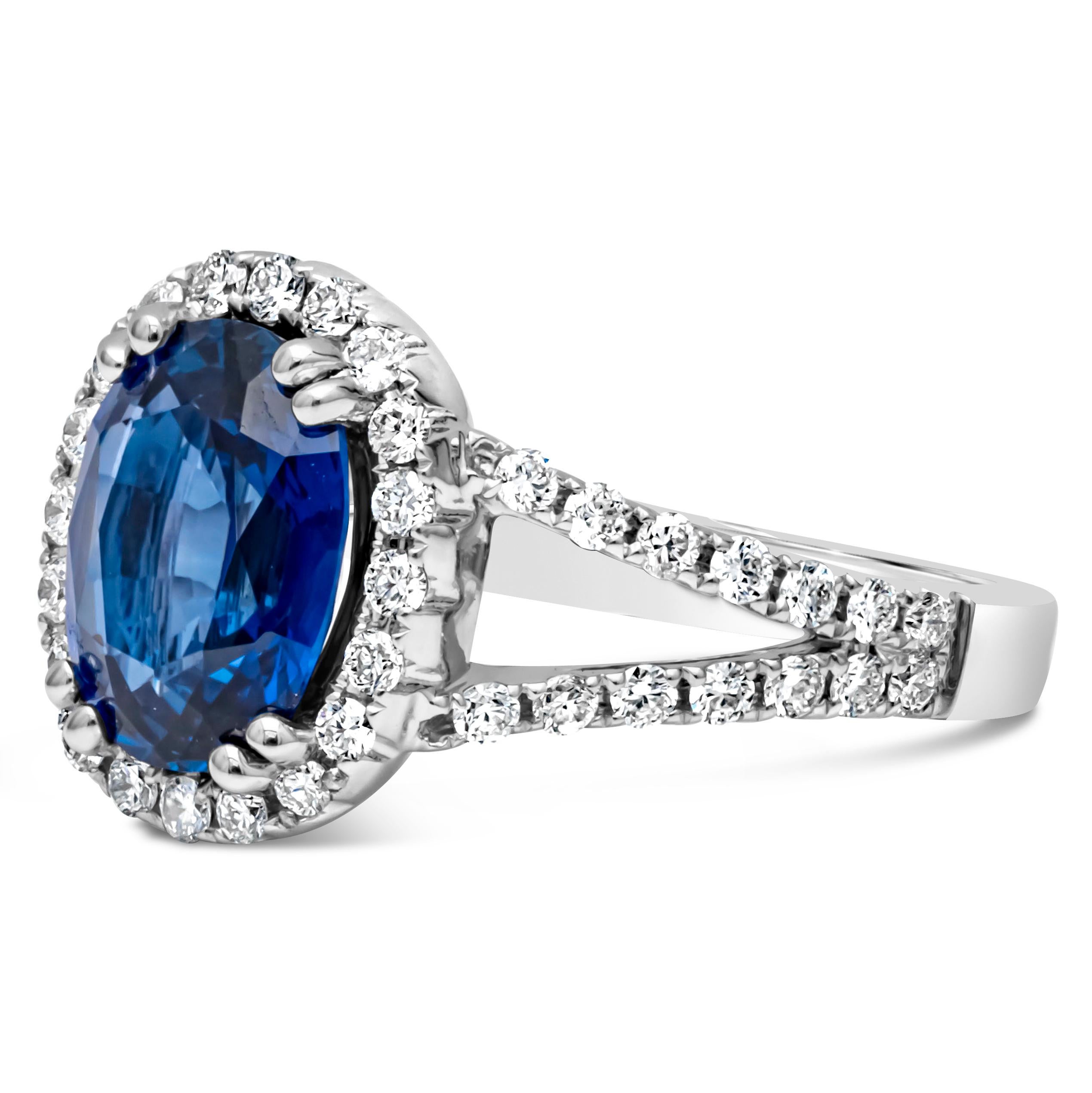 This elegant and stunning halo engagement ring features a GIA certified oval cut natural heated Sri-Lanka blue sapphire weighing 2.68 carats total, set in a timeless eight prong basket setting. Surrounded by a single row of brilliant round diamonds