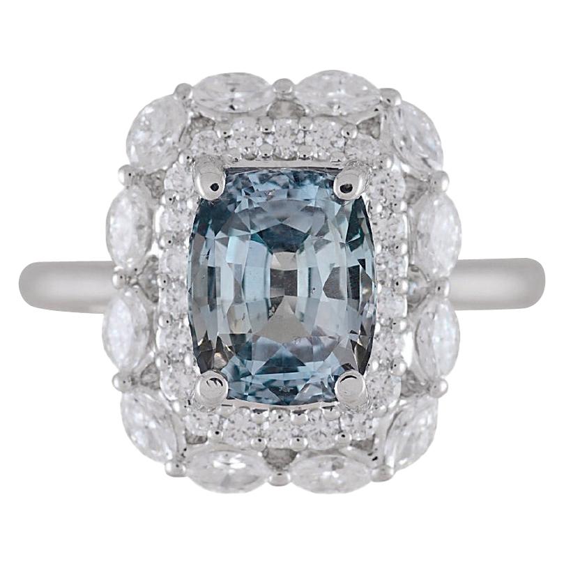 Featuring a GIA Certified 2.69 carat cushion-cut Gray-Blue sapphire at its center, elegantly encircled by a double halo composed of both round and marquise-cut white diamonds with a total diamond weight of 0.76 carats, this ring exudes radiance from