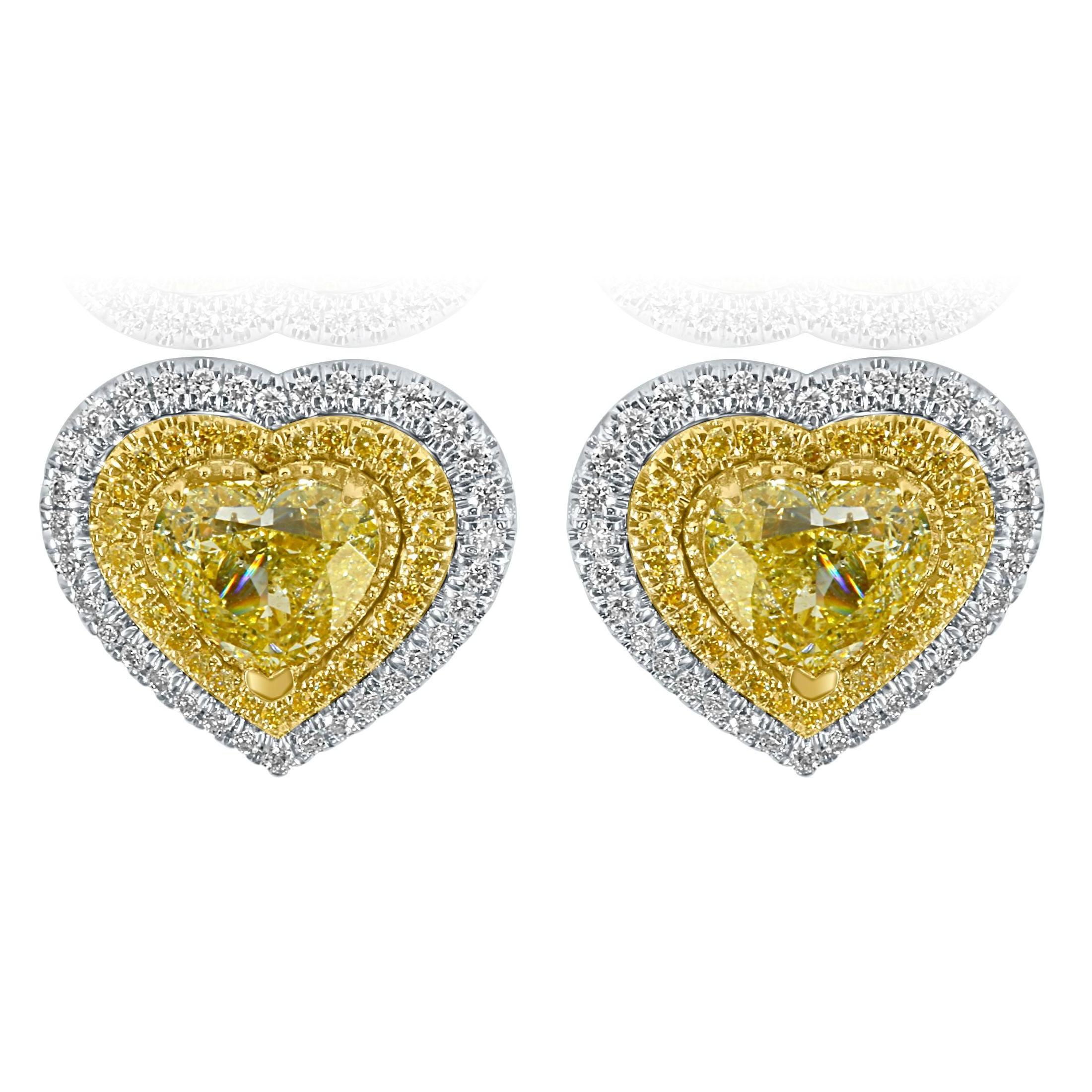 Erhöhen Sie Ihre Eleganz mit unseren atemberaubenden Ohrsteckern mit GIA-zertifizierten Diamanten. Jeder Ohrring besticht durch einen 1 Karat und 1,10 Karat schweren gelben herzförmigen Diamanten, der von einem doppelten Halo aus gelben und