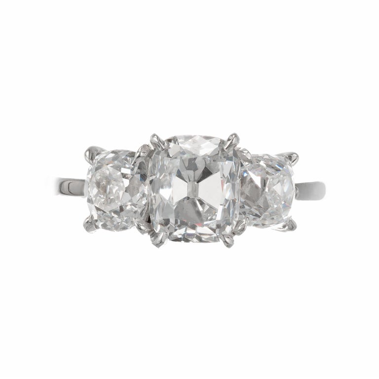 Three-stone diamond engagement ring. Old mine cushion cut center stone with two oval old mine cut side diamonds set in a platinum three-stone setting. Raised table cut tops shape and faceting. All stones GIA certified. 

1 Early old mine cushion cut