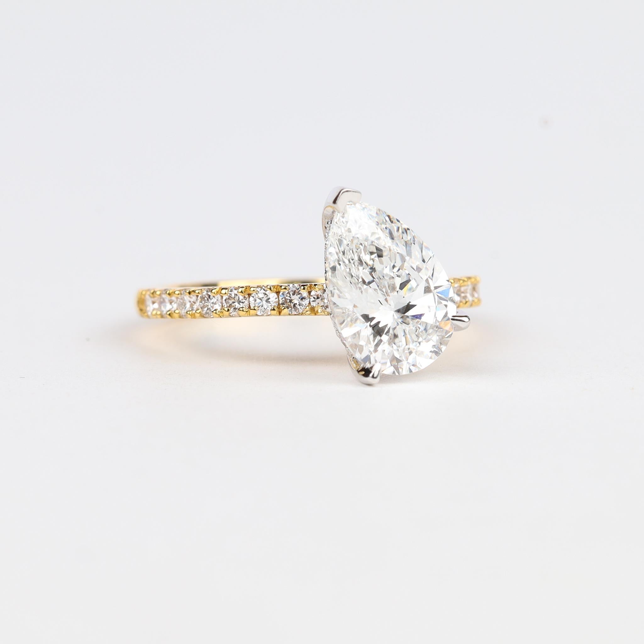 Stummes Feuer, Art-Deco-Gelassenheit

Der Mittelpunkt dieses Rings ist ein atemberaubender 2,10-karätiger natürlicher Diamant im Birnenschliff - GIA-zertifiziert, Farbe E, Reinheit VVS1 für kristalline Brillanz -, der sich durch seine Schlichtheit