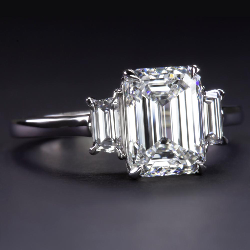 Élevez votre style avec la beauté inégalée de cette bague en or blanc 18k certifiée GIA et ornée de deux diamants trapézoïdaux de 3 carats taille émeraude. Au cœur de cette magnifique bague brille un époustouflant diamant taille émeraude, certifié