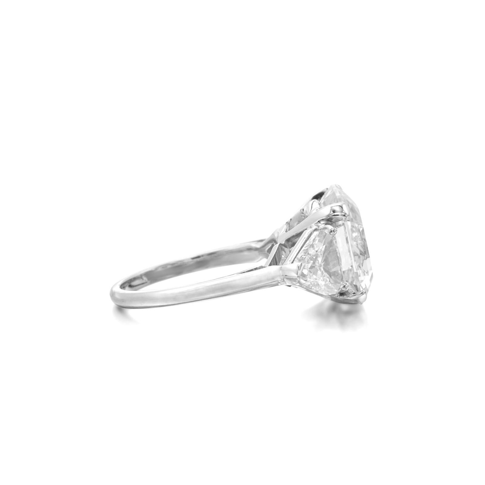 Dieser raffinierte Verlobungsring ist mit einem GIA-zertifizierten, quadratischen Diamanten im Smaragdschliff von 3,02 Karat in 18 Karat Weißgold gefasst und bietet ein Gleichgewicht zwischen Struktur und Eleganz. 

Der zentrale Edelstein hat den