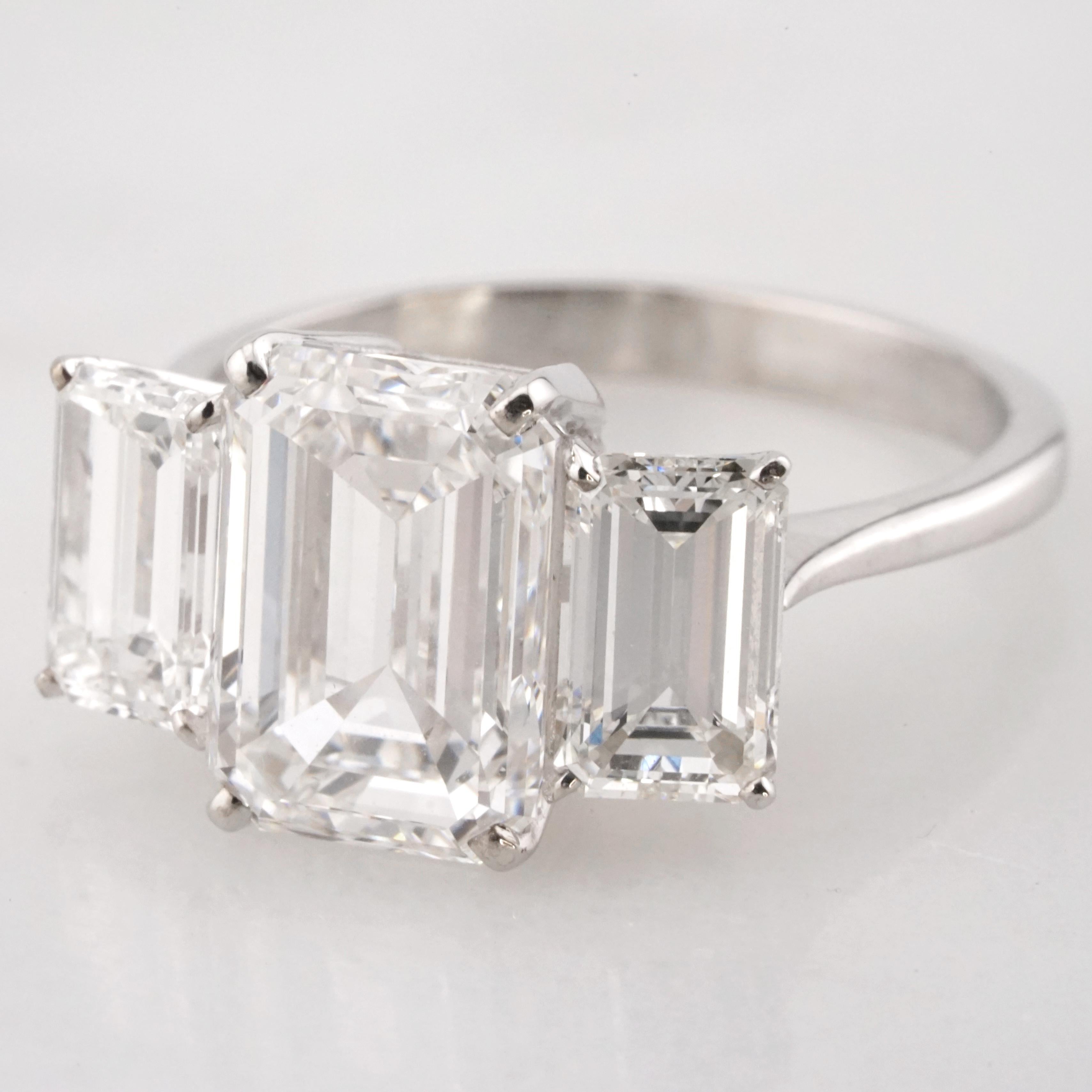 Imbued with an air of sophistication and expert artisanship, this engagement ring stands as a paragon of classic beauty. At the heart of its design lies a remarkable 3-carat emerald-cut diamond, a beacon of brilliance and purity. Its authenticity