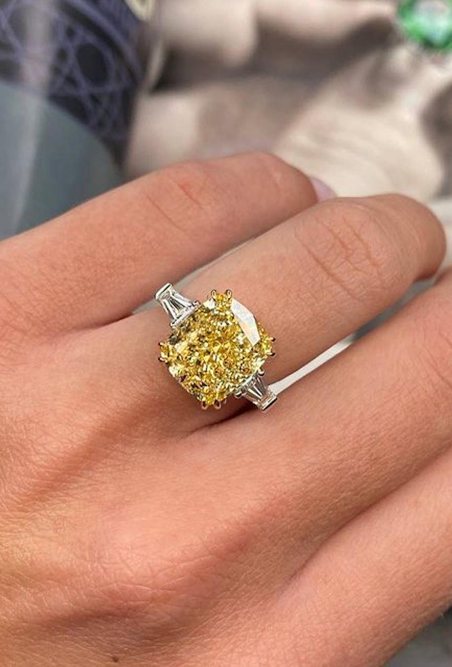 An exquisite GIA certified fancy intense yellow cushion cut diamond ring with two side tapered baguette natural diamonds at each side mounted in 18 carats yellow gold and white gold.

The main stone has a strong yellow. The stone has an intense