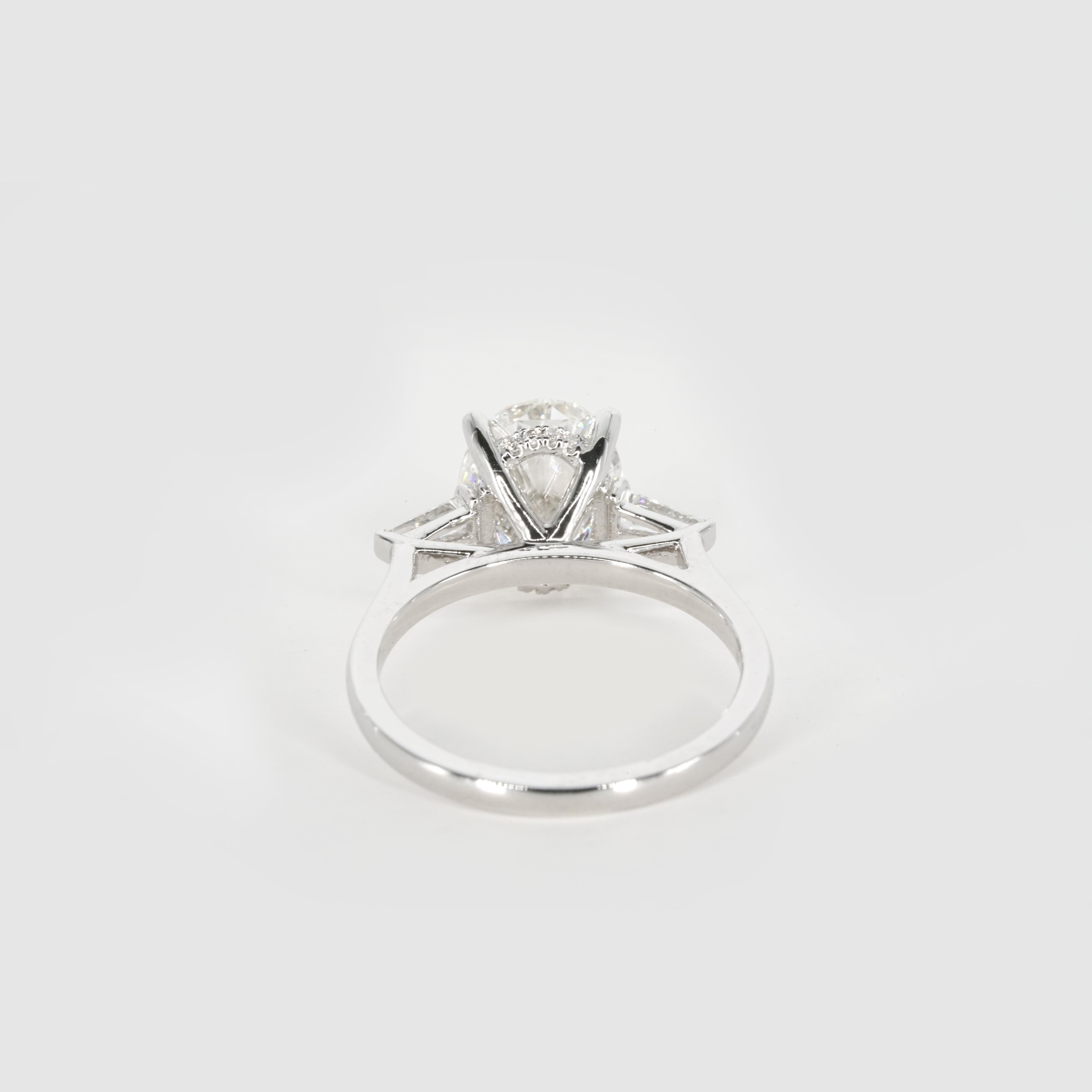 Questo elegante design di Cecil Blake presenta al centro uno splendido diamante di taglio ovale certificato GIA, di colore I. Il diamante vanta una brillantezza eccezionale e una forma splendidamente simmetrica, che emana una raffinatezza senza