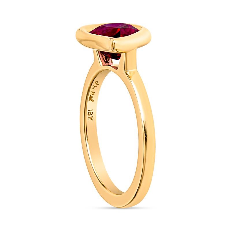 This unique ring showcases a vibrant 3.00 carat pear-shaped untreated Tanzanian ruby in a polished 18 karat yellow gold bezel setting. Its freeform design adds an artistic flair, making it a captivating choice for any occasion. It is currently a