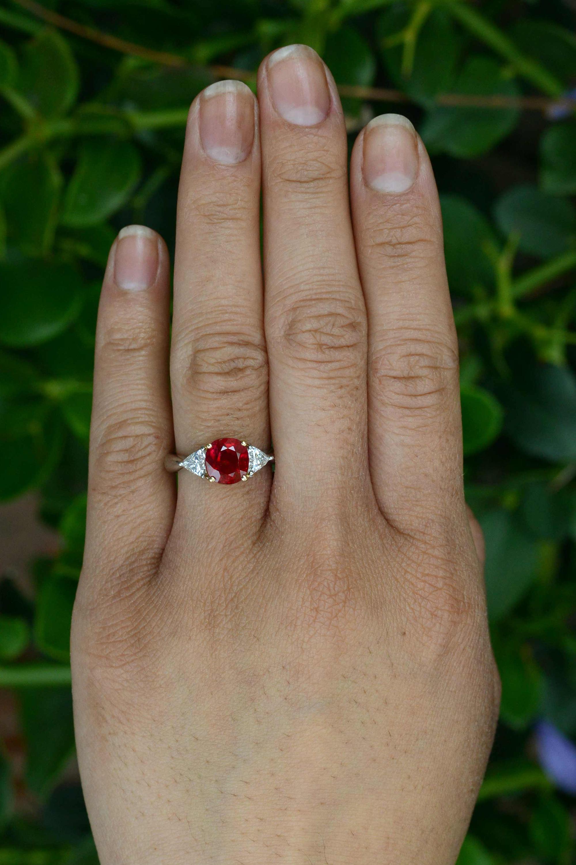 Boasting a rare, 3 carat GIA certified pigeon blood red Burma ruby commanding center stage, accompanied by a pair of fiery, sparkling triangle diamonds, this 3 stone stunner is a real show-stopper. The vivid color of Burmese rubies is prized among