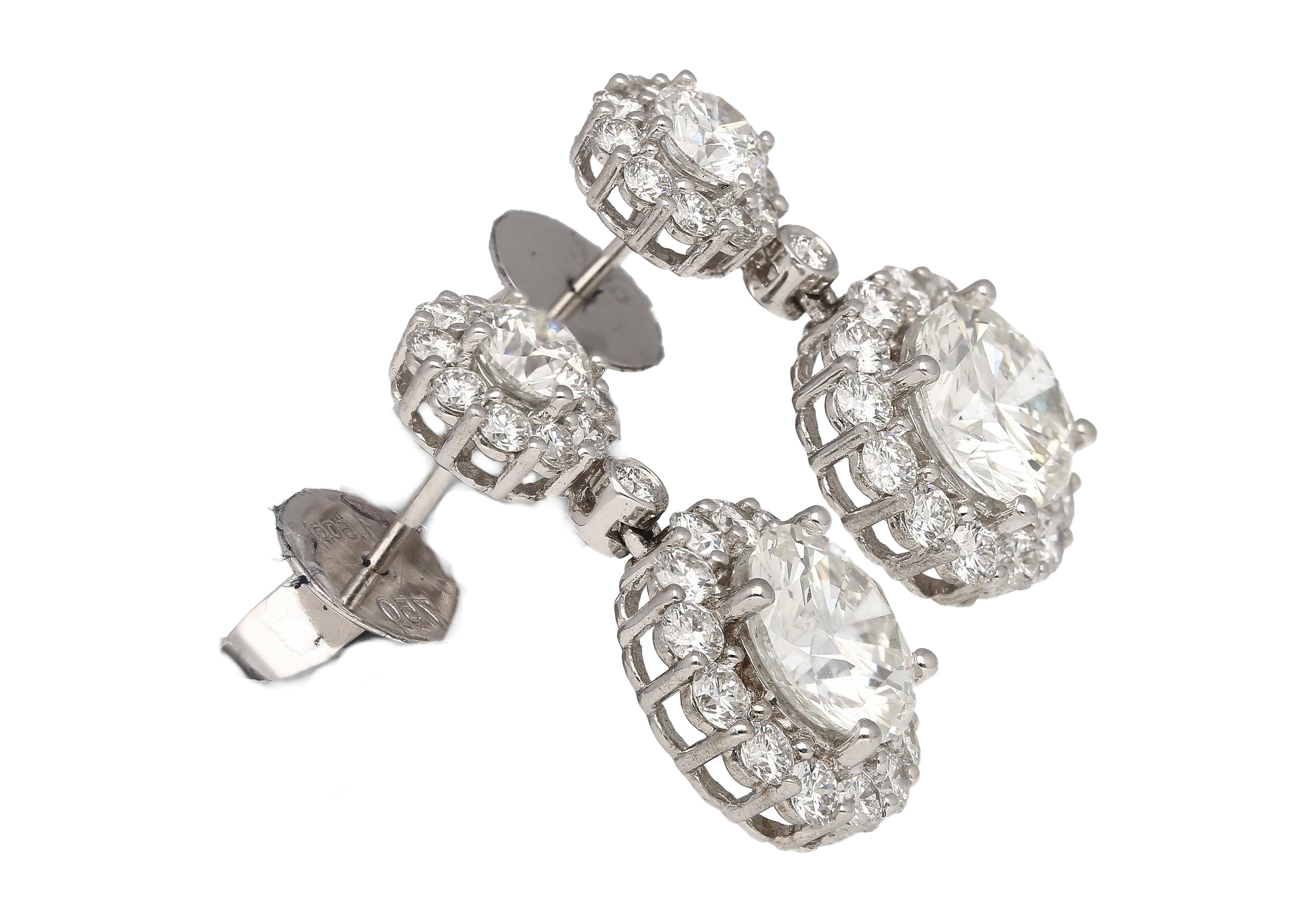 These drop earrings showcase a captivating duo of round diamonds, each boasting 1.51 and 1.50 carats. Graded H for near-colorless beauty and VS2 clarity, they sparkle with exceptional brilliance. Their elegance is further amplified by a sparkling