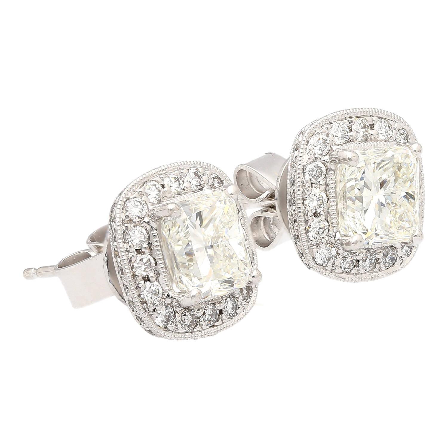 Boucles d'oreilles composées de diamants naturels de taille radieuse de 3 carats au total. Serti en or blanc 18k d'un halo de diamants de taille ronde et d'une fermeture push-back. Avec un diamant de 1,50 carat certifié par la GIA et de 1,51 carat